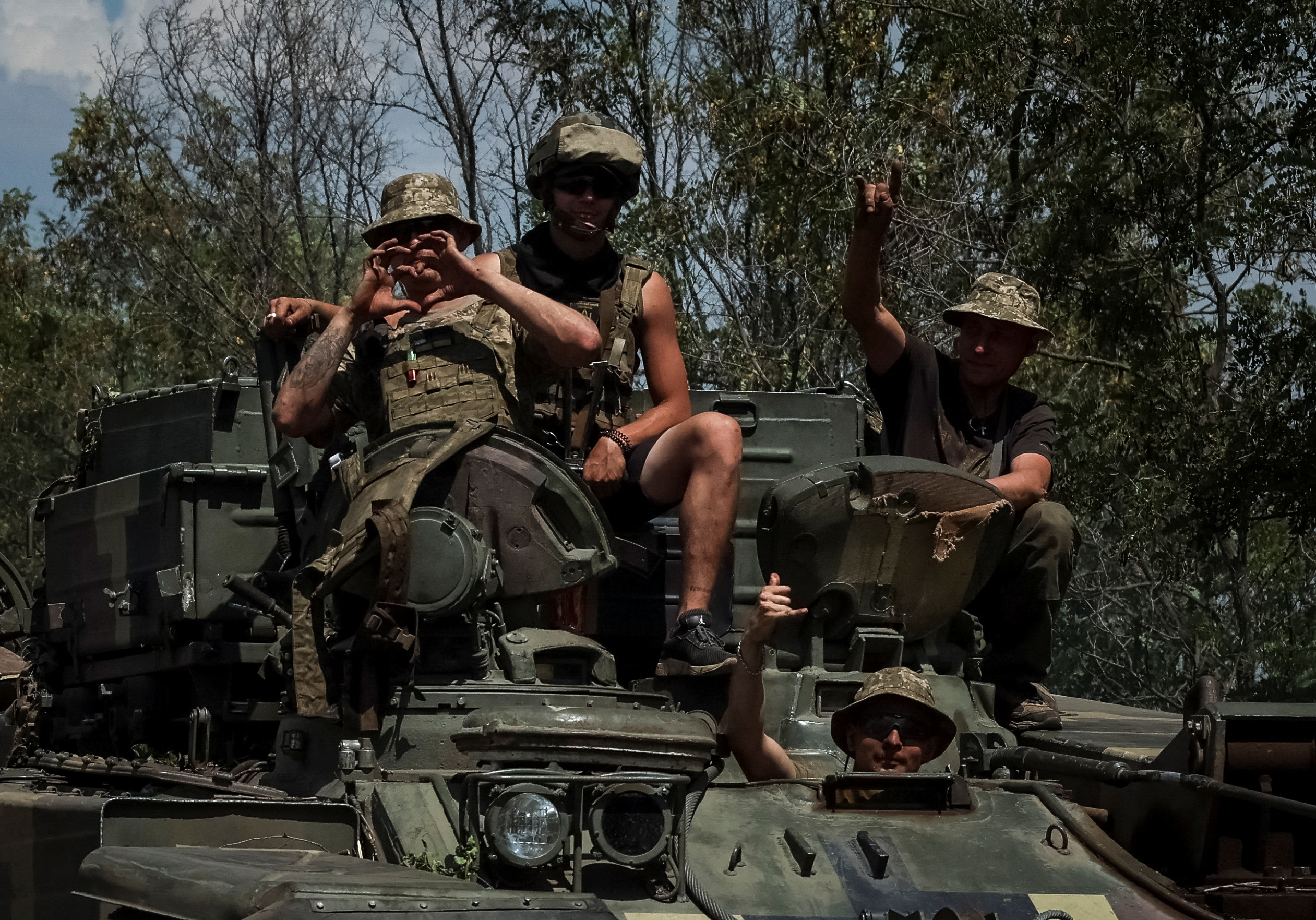 Militares ucranianos gesticulan mientras viajan en un vehículo militar, en medio del ataque de Rusia a Ucrania, en la región de Donetsk. REUTERS/Gleb Garanich 