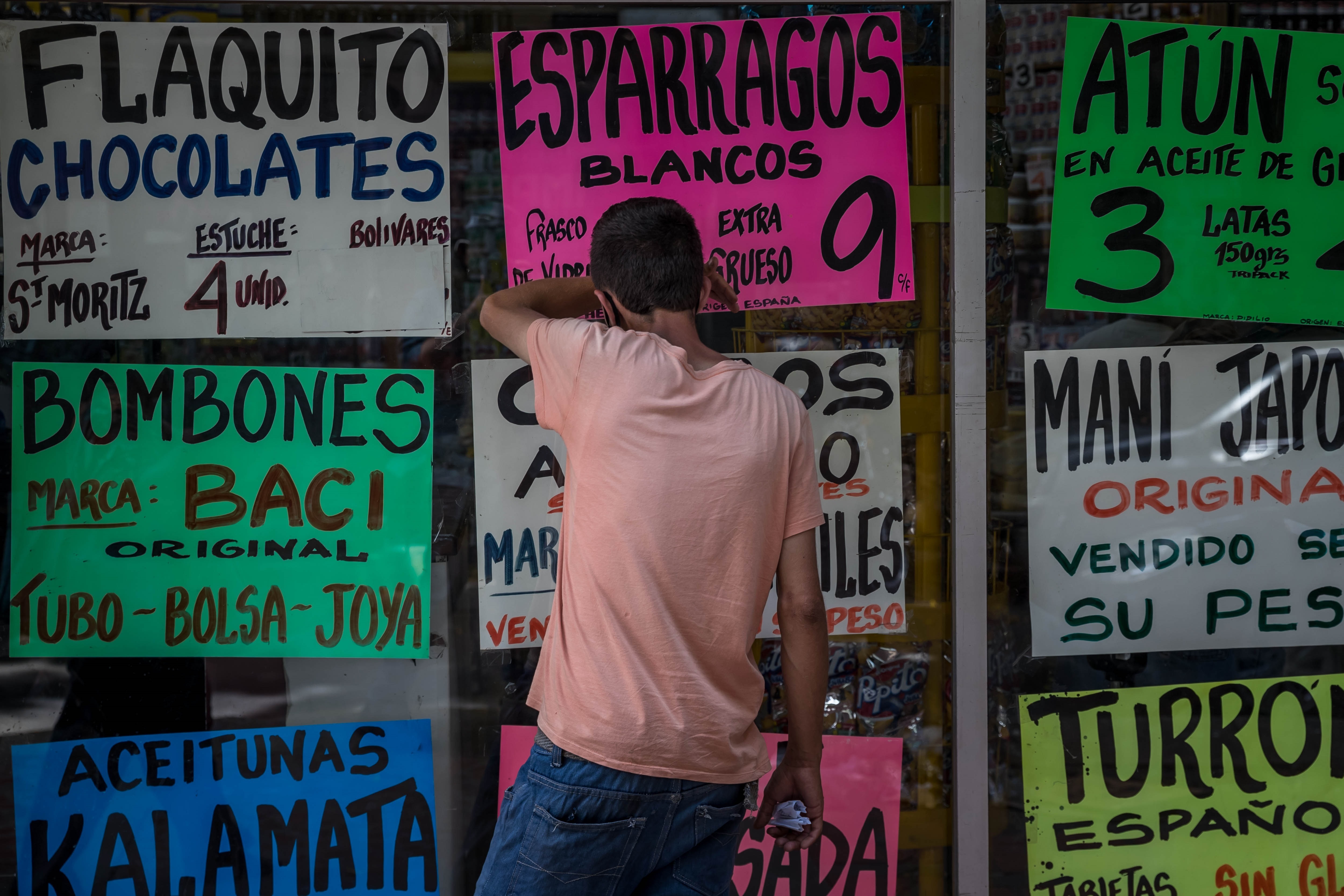 Un hombre observa dentro de una vitrina de la que cuelgan carteles con precios de alimentos el 15 de octubre de 2020, en Caracas (Venezuela). EFE/ Miguel Gutiérrez/Archivo
