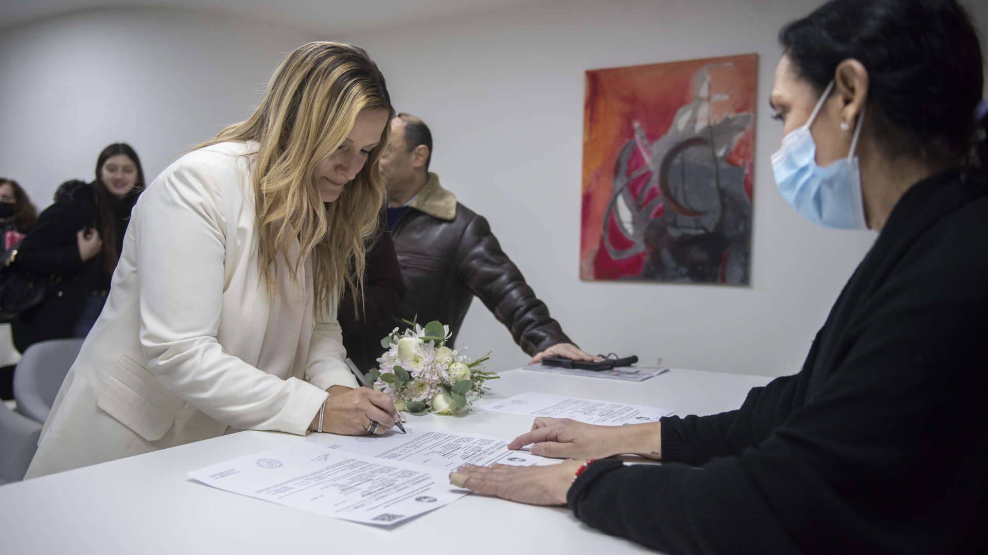 Valeria firma el documento que certifica la unión civil en la Sede Comunal 15 de CABA ante la mirada de la jueza Natacha Alejandra Prado, que se emocionó con la historia de ambos (Foto: Adrián Escandar)