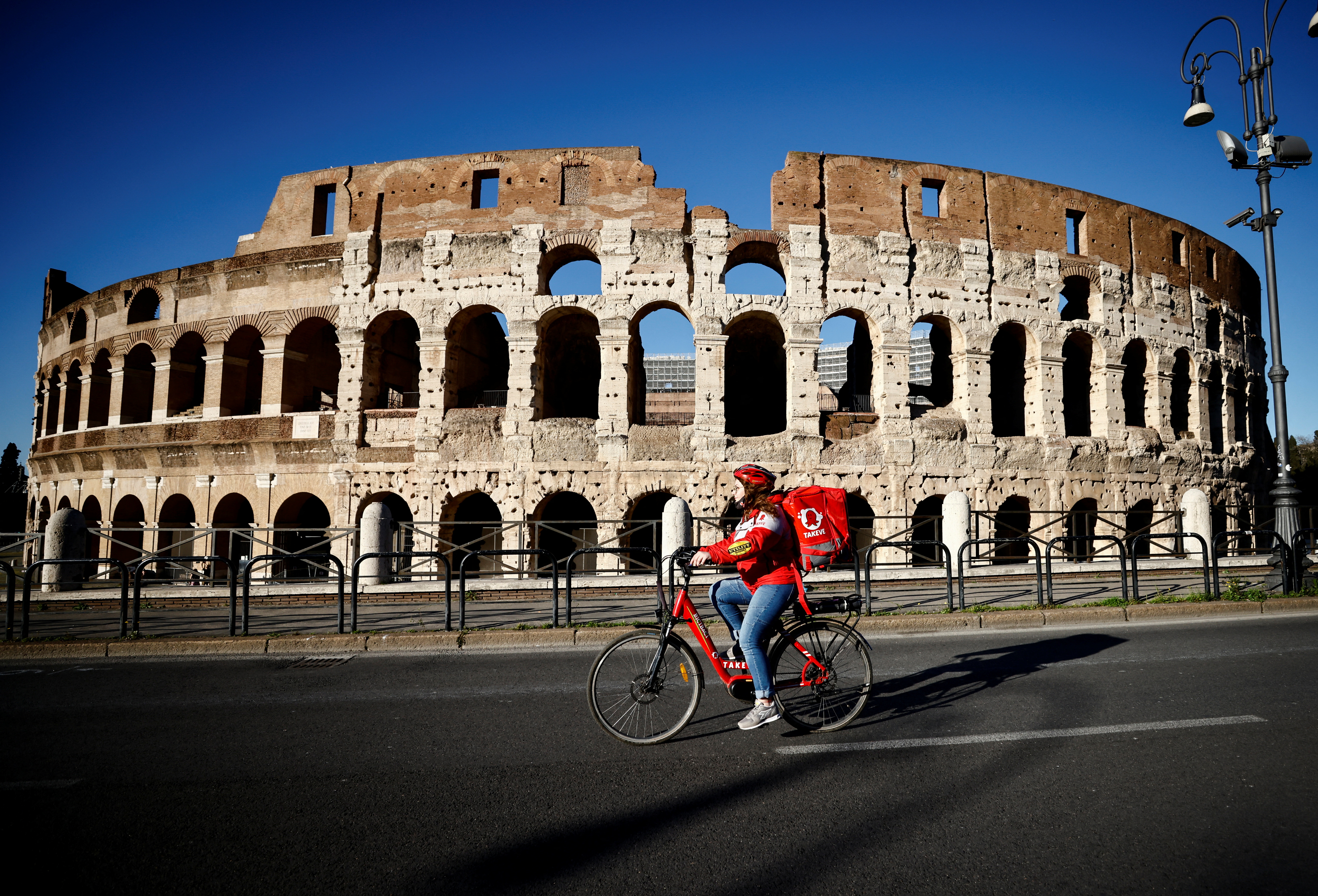 Una repartidora frente al Coliseo en Roma (REUTERS/Yara Nardi)
