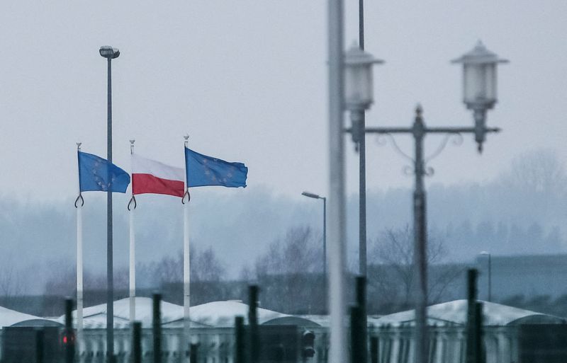 Una vista desde el lado bielorruso de la frontera muestra banderas polacas y de la UE trás una valla en el puesto de control de Bruzgi-Kuznica en la frontera bielorrusa-polaca durante la crisis de los migrantes en la región de Grodno (REUTERS/Maxim Shemetov)
