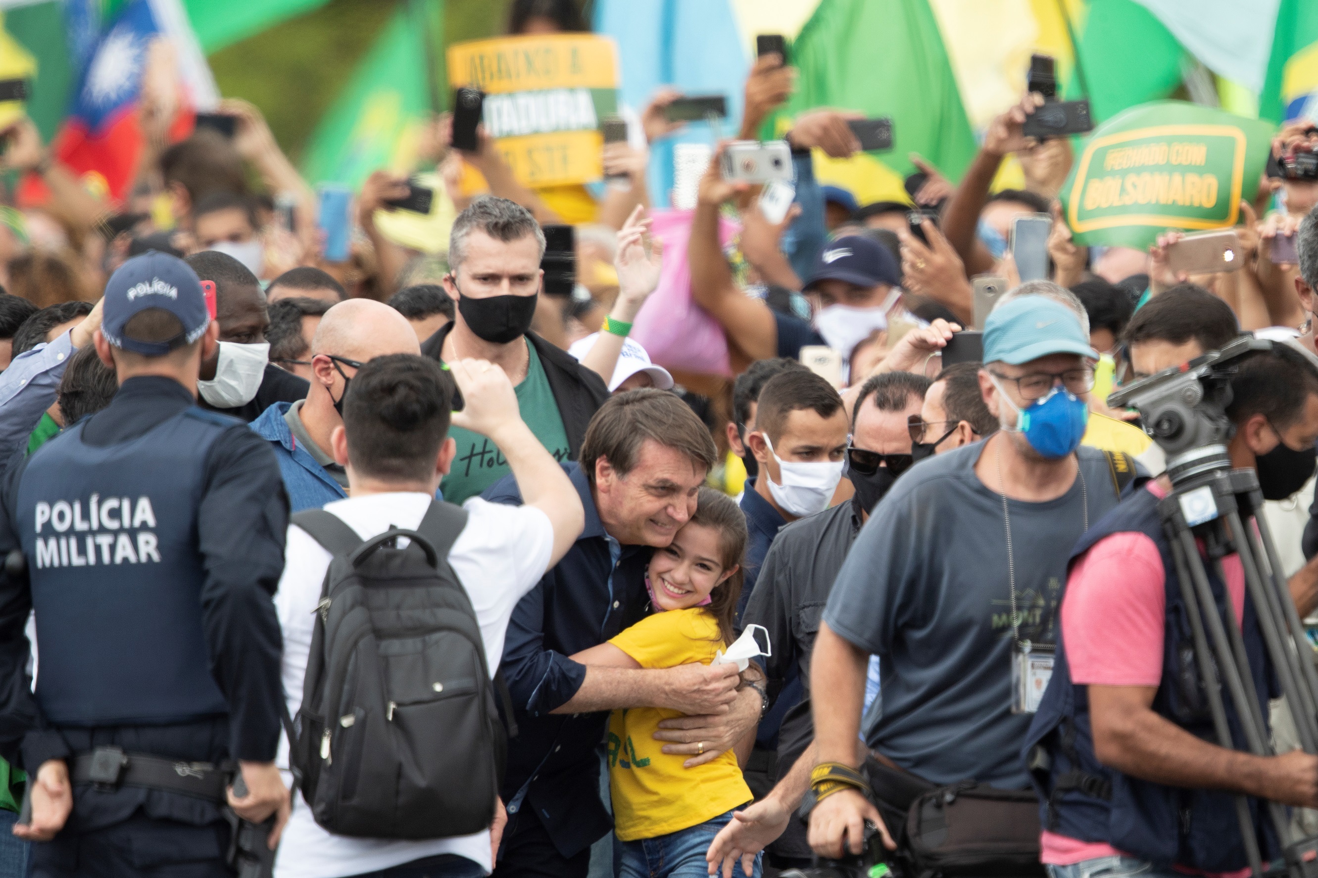 El presidente de Brasil, Jair Bolsonaro, saluda a una niña este domingo, en Brasilia (Brasil), sin ninguna medida de aislamiento social. EFE/Joédson Alves