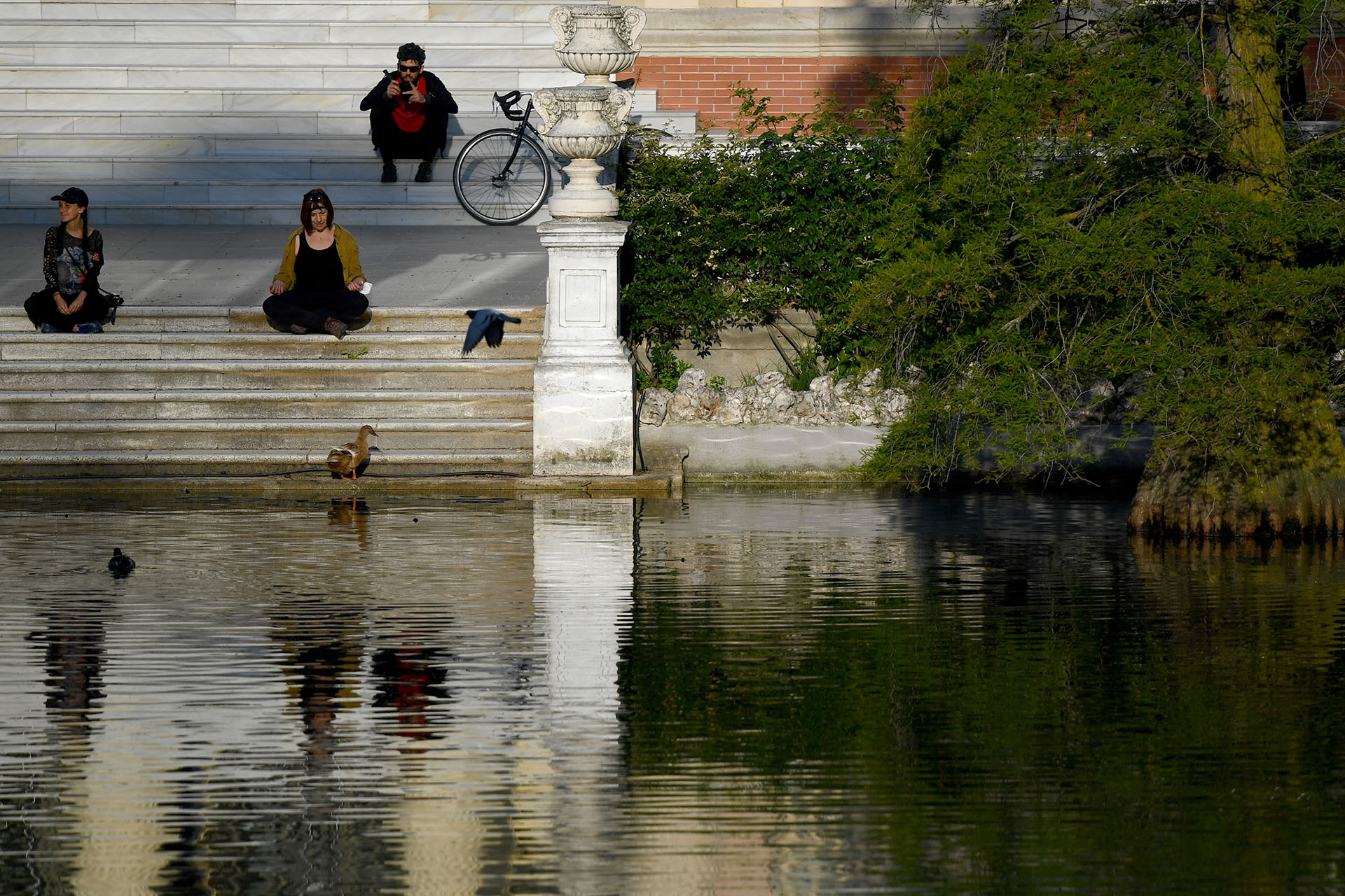 Personas disfrutan del sol en el parque El Retiro. Otro ejemplo de la recuperación de la normalidad es que los reyes impulsarán a partir de esta semana su agenda de actos fuera del Palacio de la Zarzuela, su residencia oficial, después de dos meses con su actividad pública muy limitada. (Gabriel BOUYS / AFP)
