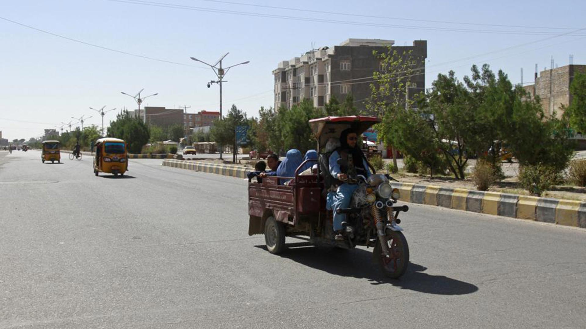 Afganos viajan en carros de motocicleta durante los combates entre los talibanes y las fuerzas de seguridad afganas en la provincia de Herat, al oeste de Kabul, Afganistán (AP)