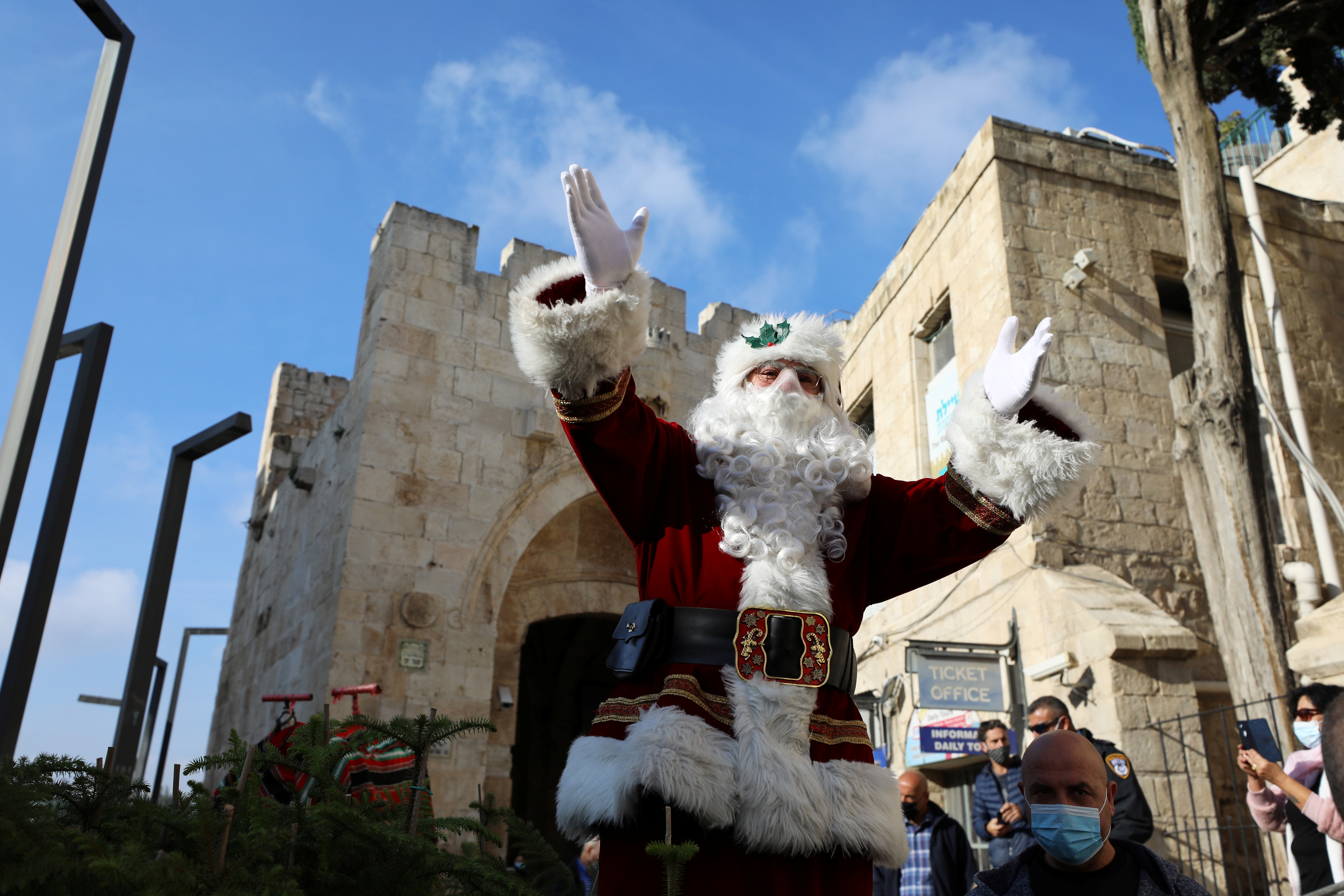 Issa Kassissieh hace un gesto mientras lleva un disfraz de Papá Noel mientras reparte árboles de Navidad a la gente (REUTERS/Ammar Awad)