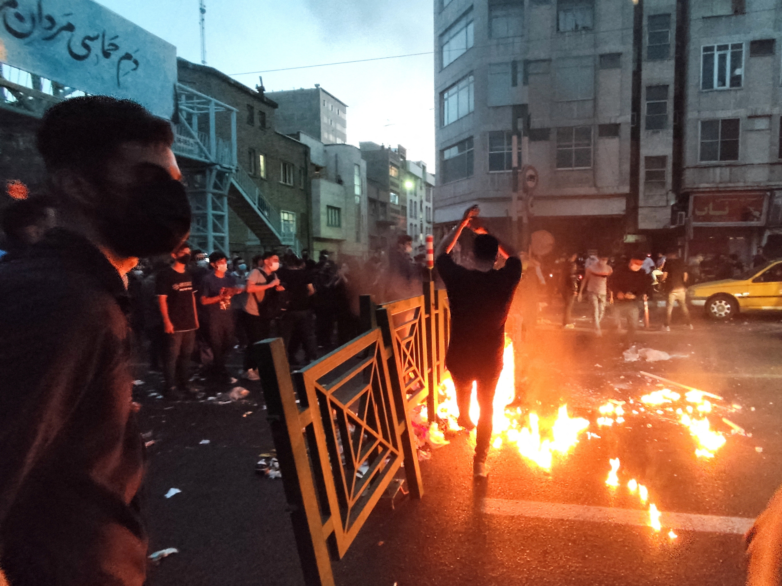 La gente enciende un fuego durante una protesta por la muerte de Mahsa Amini, una mujer que murió después de ser arrestada por la "policía de la moralidad" de la república islámica, en Teherán, Irán, el 21 de septiembre de 2022. (WANA vía REUTERS)