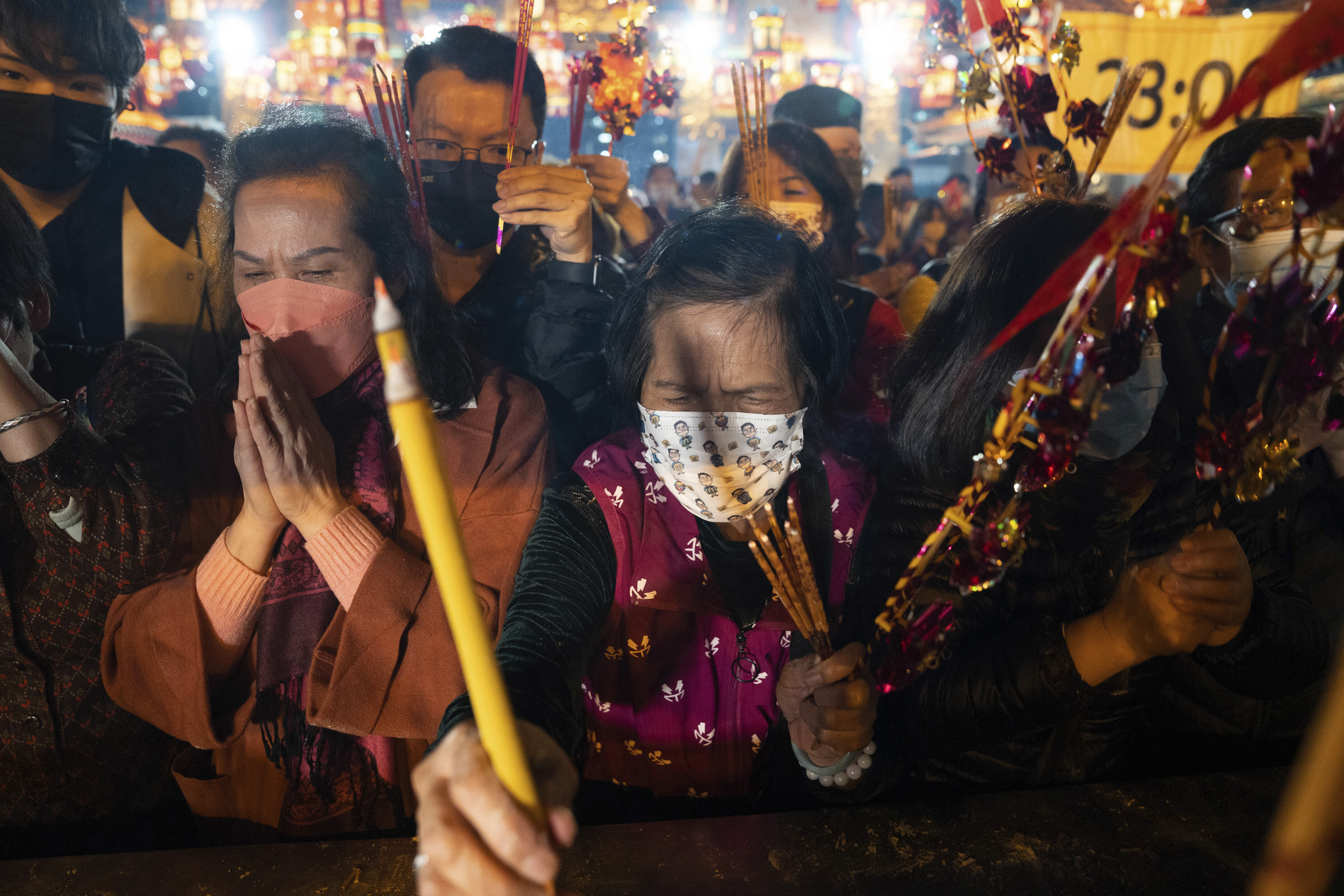 Worshipers wearing face masks burn their first incense sticks as they pray at Wong Tai Sin Temple in Hong Kong on Saturday, January 21, 2023, to celebrate the start of the Lunar New Year.  (AP Photo/Bertha Wang)