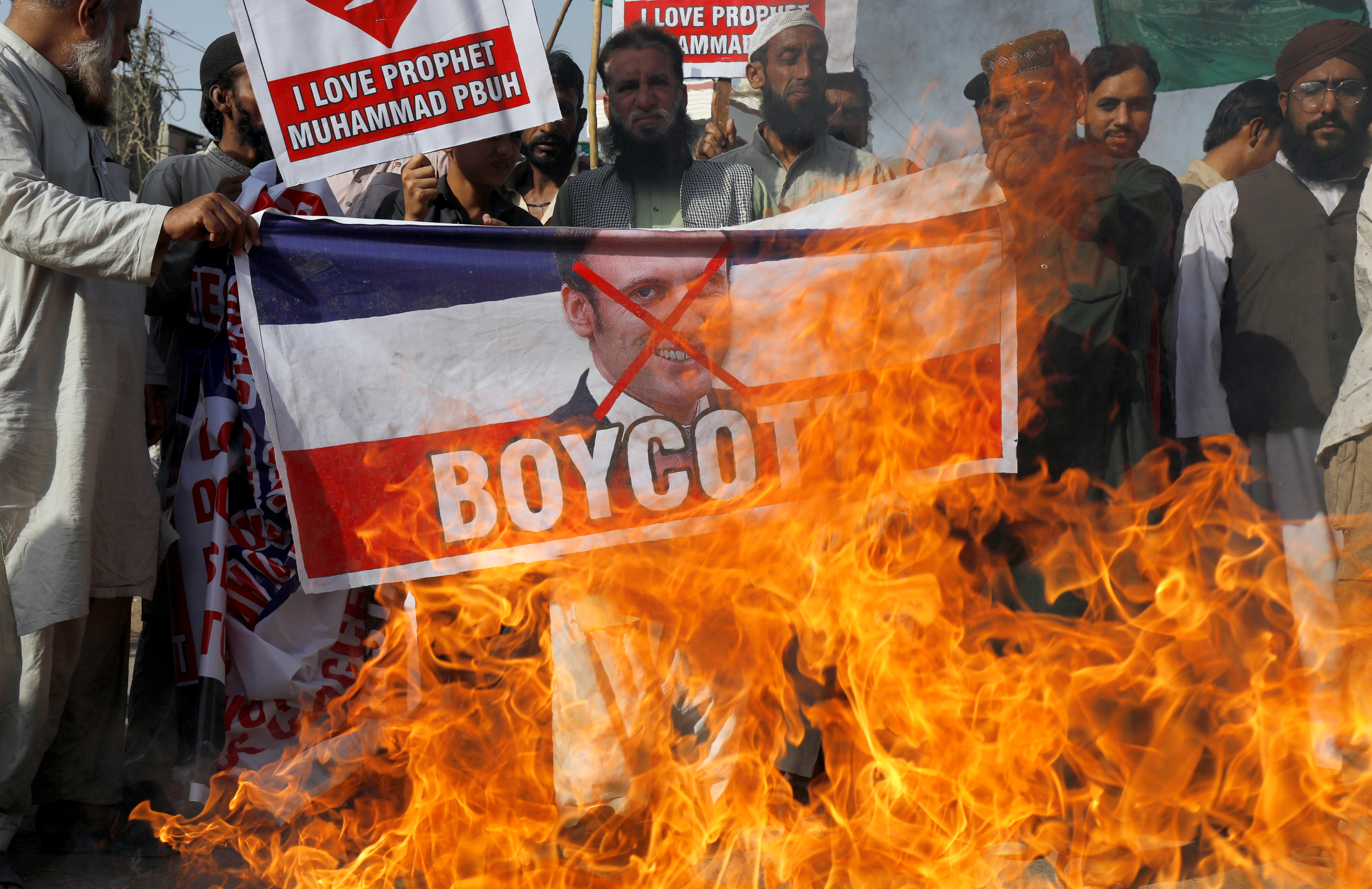 Manifestantes queman una pancarta con la foto de Macron en Karachi, Pakistán (Reuters/ Akhtar Soomro)