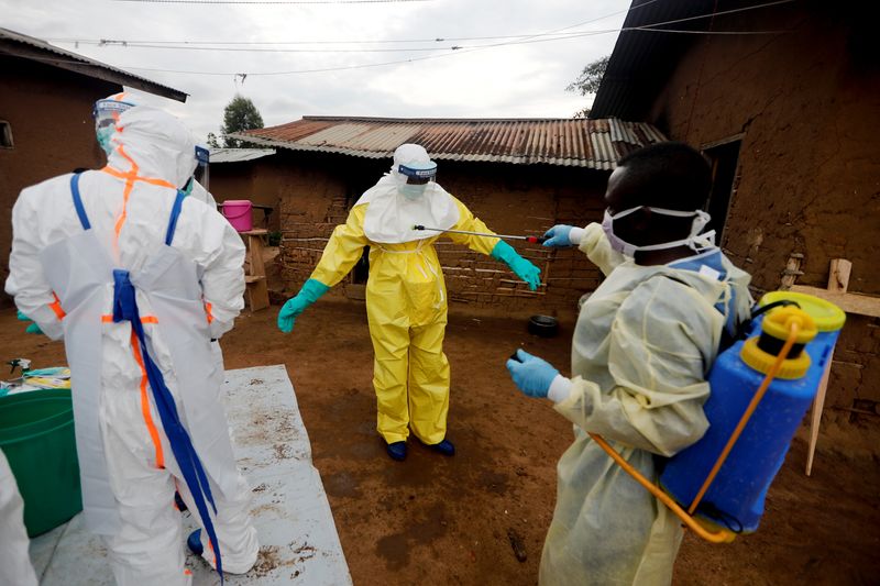 Un trabajador sanitario desinfecta a un compañero antes de acceder a la casa de una mujer de 85 años sospechosa de haber muerto a causa del ébola 