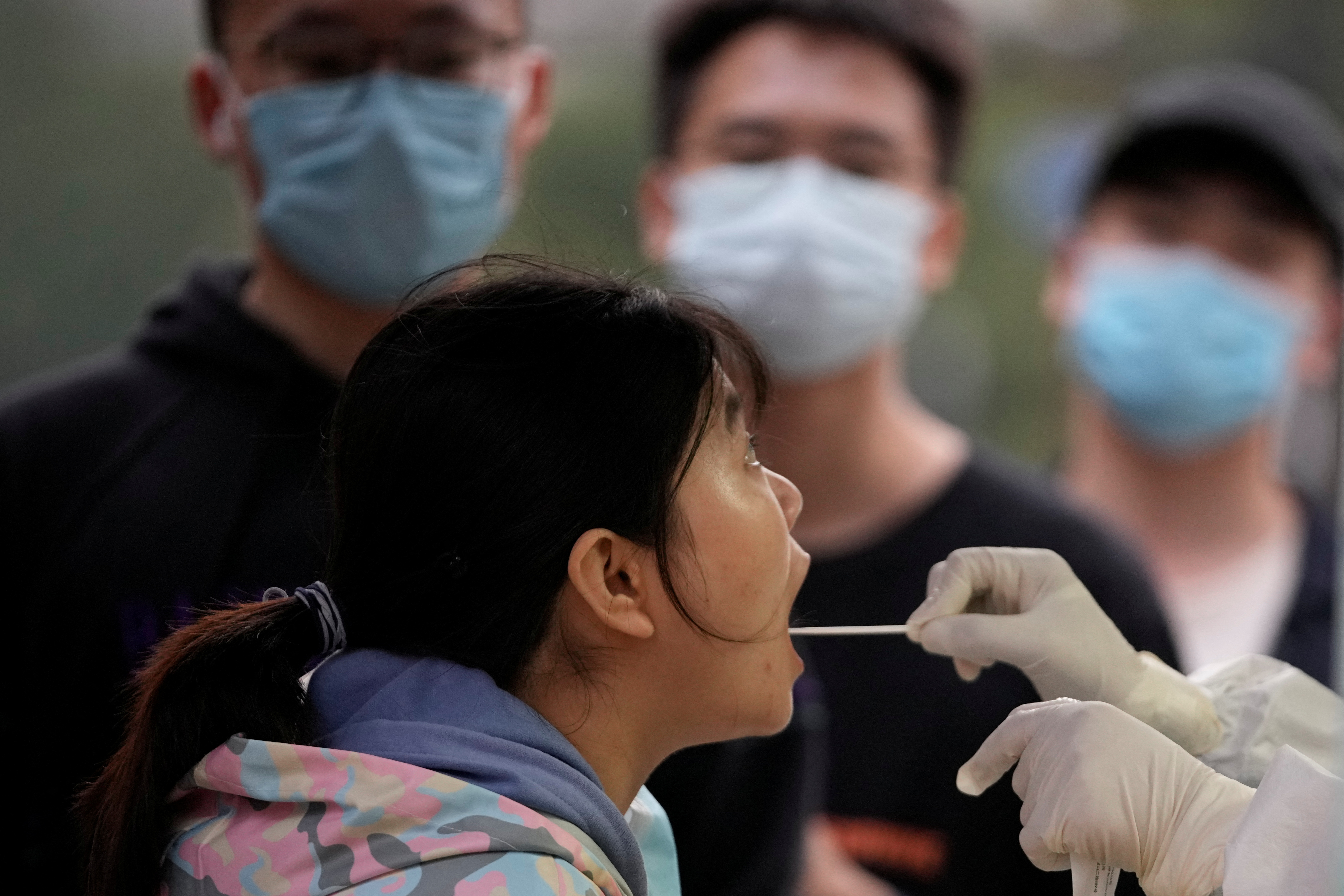 Una mujer se hace la prueba de coronavirus como parte de la política de cero COVID del régimen chino