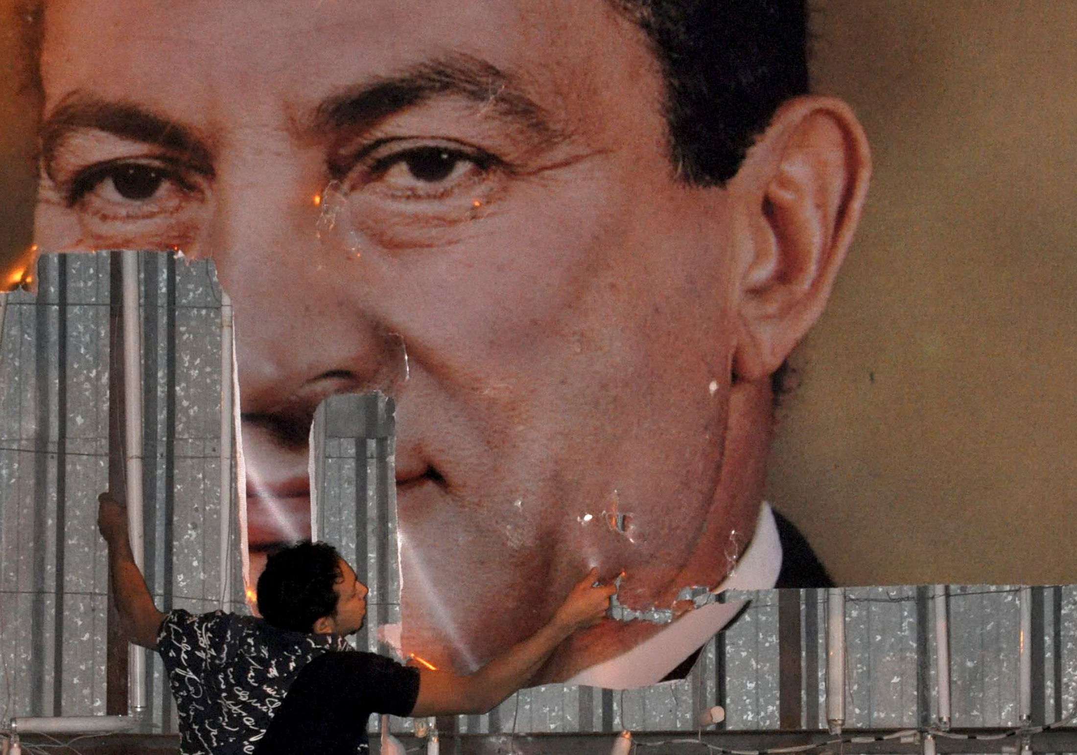 Un manifestante desfigura una imagen del presidente egipcio Hosni Mubarak en Alejandría, el 25 de enero de 2011 (REUTERS/Stringer/File Photo)