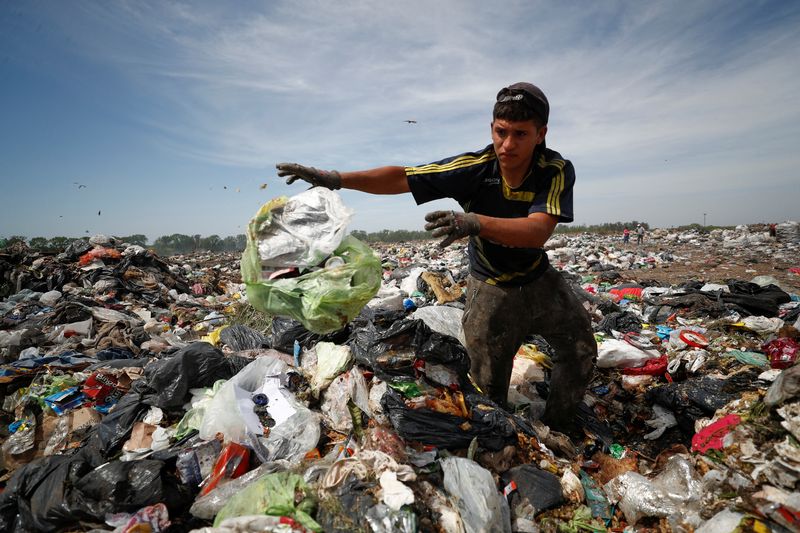Diego, de 19 años, revuelve la basura en busca de cartones, plásticos y metales para vender como forma de sobrevivir a una inflación estimada del 100% este año en Argentina, una de las más altas del mundo, en el basural de Luján, en las afueras de Buenos Aires, Argentina, el 5 de octubre de 2022. REUTERS/Agustín Marcarian