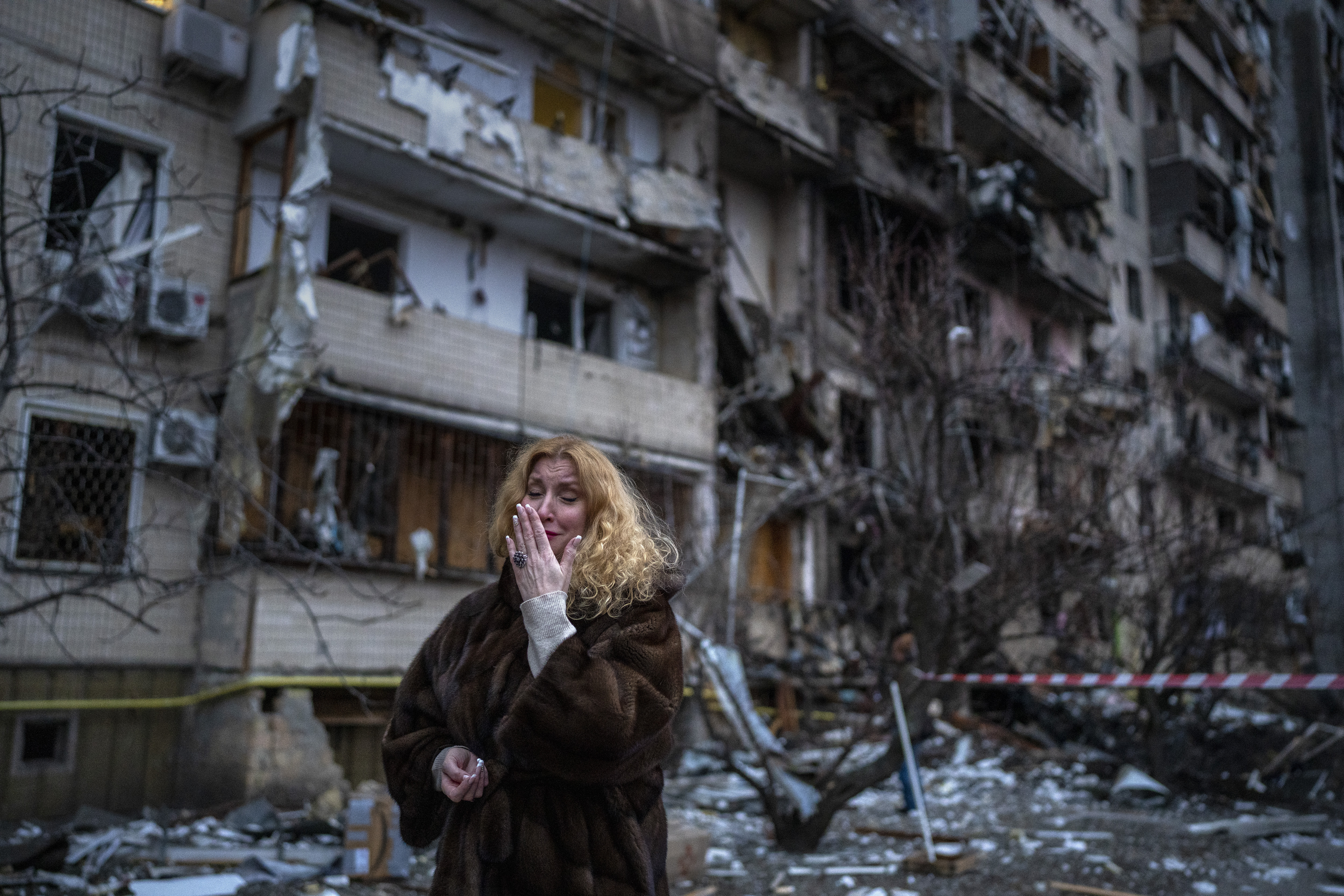 Una mujer reacciona junto a su casa luego de un ataque con cohetes en la ciudad de Kiev, Ucrania, el viernes 25 de febrero de 2022. (Foto AP/Emilio Morenatti)