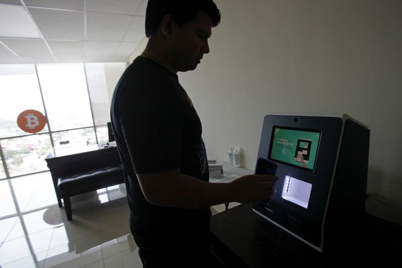 Juan Mayén, 28, CEO of Honduran firm TGU Consulting Group, poses for a photo showing how to use a cryptocurrency ATM, the first in the country that allows users to purchase Bitcoin and Ethereum using the local currency Lempira , in Tegucigalpa, Honduras.  August 27, 2021. REUTERS/Fredy Rodriguez