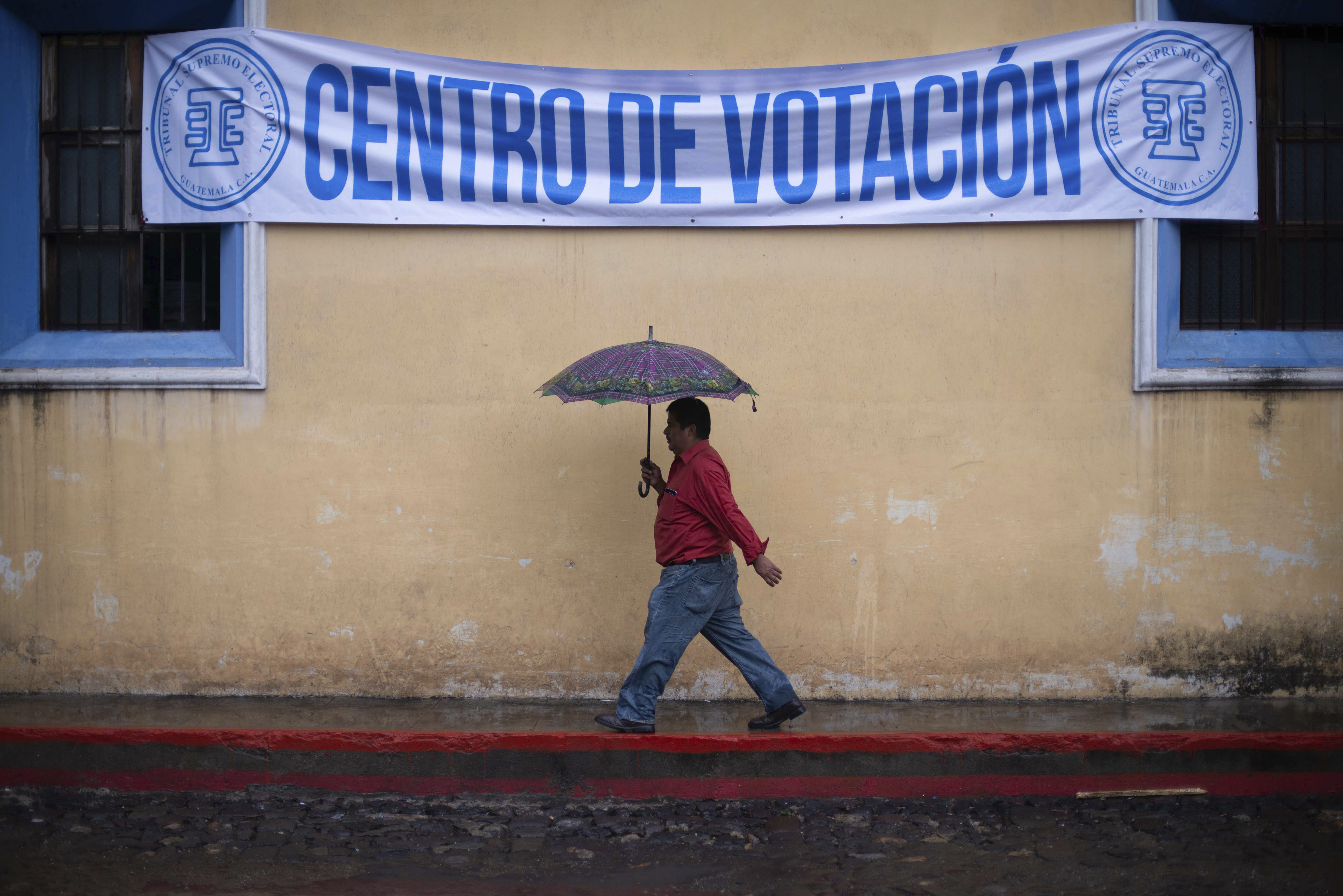 Un hombre camina en la lluvia rumbo a un centro de votación  (AP Foto/Santiago Billy)