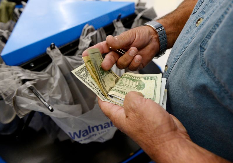 Imagen de archivo de un cliente contando dólares en un supermercado Walmart de Los Ángeles, EEUU. 26 noviembre 2013. REUTERS/Kevork Djansezian