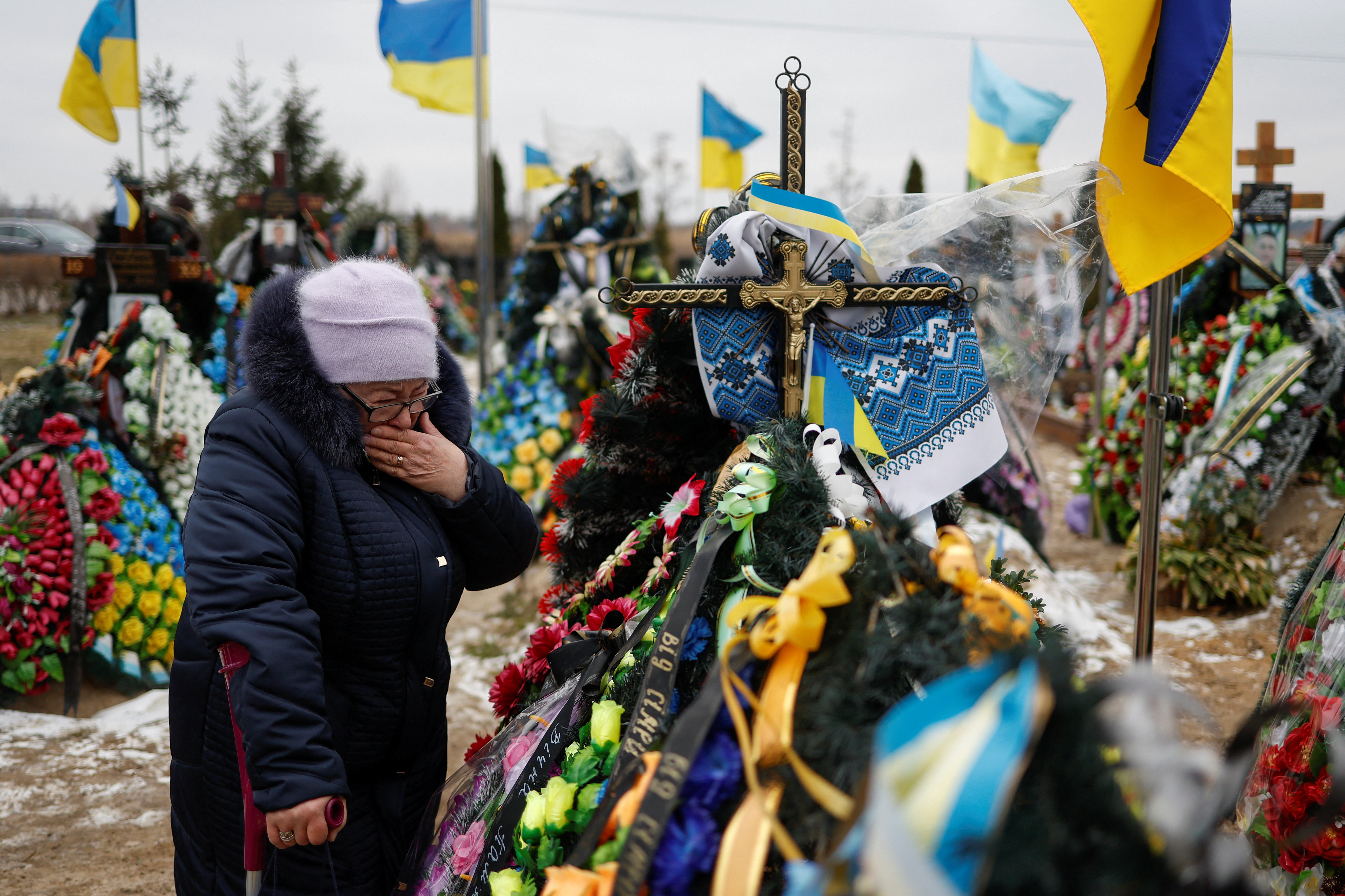 Mariia Kurbet visita la tumba de su hijo, Vasyl, en el cementerio de Bucha. Allí están enterradas las víctimas de algunos de los peores crímenes de guerra cometidos por los rusos en esta invasión a Ucrania. (REUTERS/Valentyn Ogirenko)