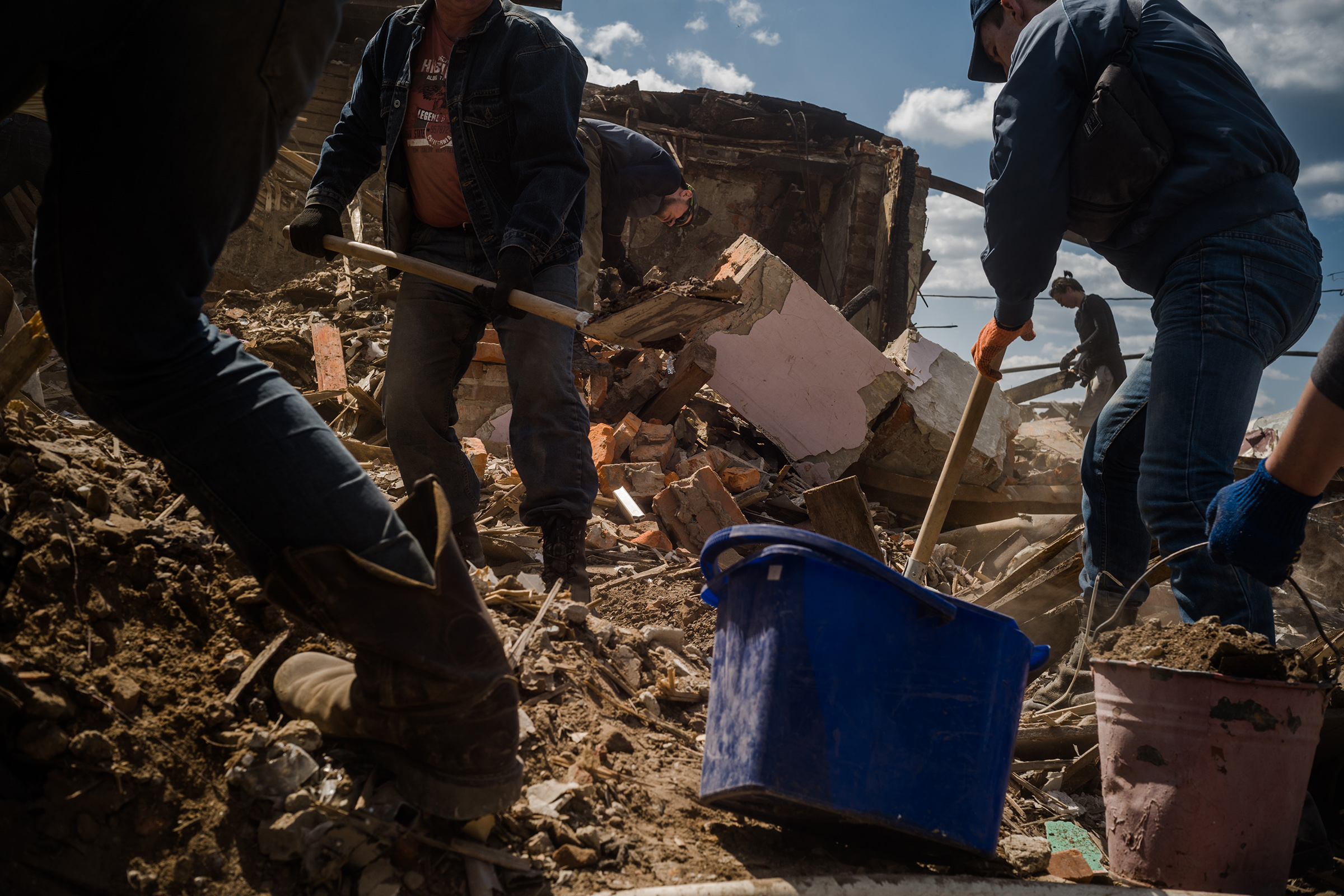 Los voluntarios trabajan en la limpieza de escombros de una sección dañada de Kharkiv. (Wojciech Grzedzinski para The Washington Post)