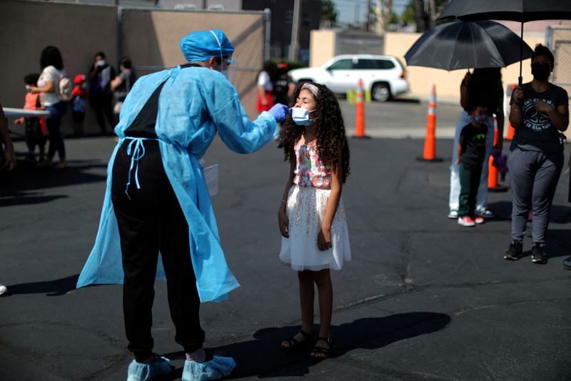 Una niña sometiéndose a un examen de COVID-19 (REUTERS/Lucy Nicholson)