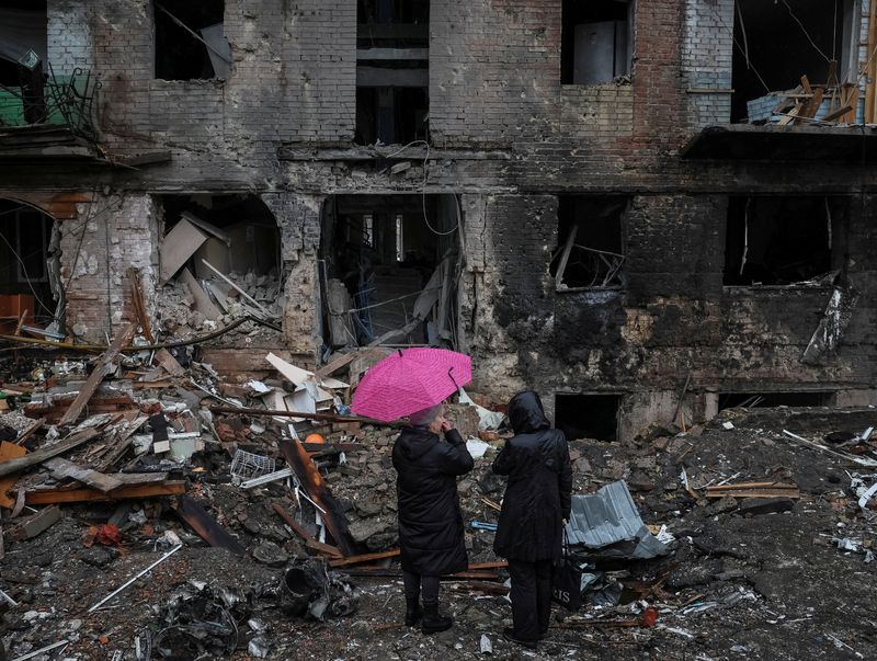 Residentes locales permanecen cerca de su edificio destruido por un ataque de misiles rusos en la ciudad de Vyshhorod, cerca de Kiev (REUTERS/Gleb Garanich)