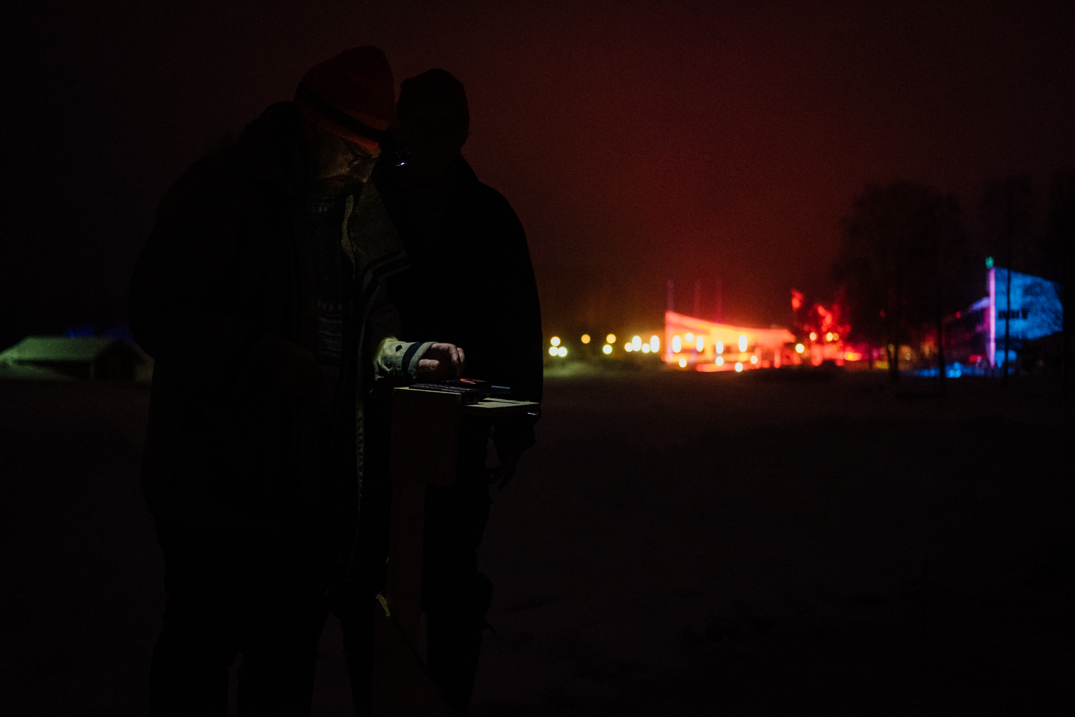 Janne Käpylehto (izq.) y un miembro de su equipo usan un láser para medir la obra (Alessandro RAMPAZZO / AFP)