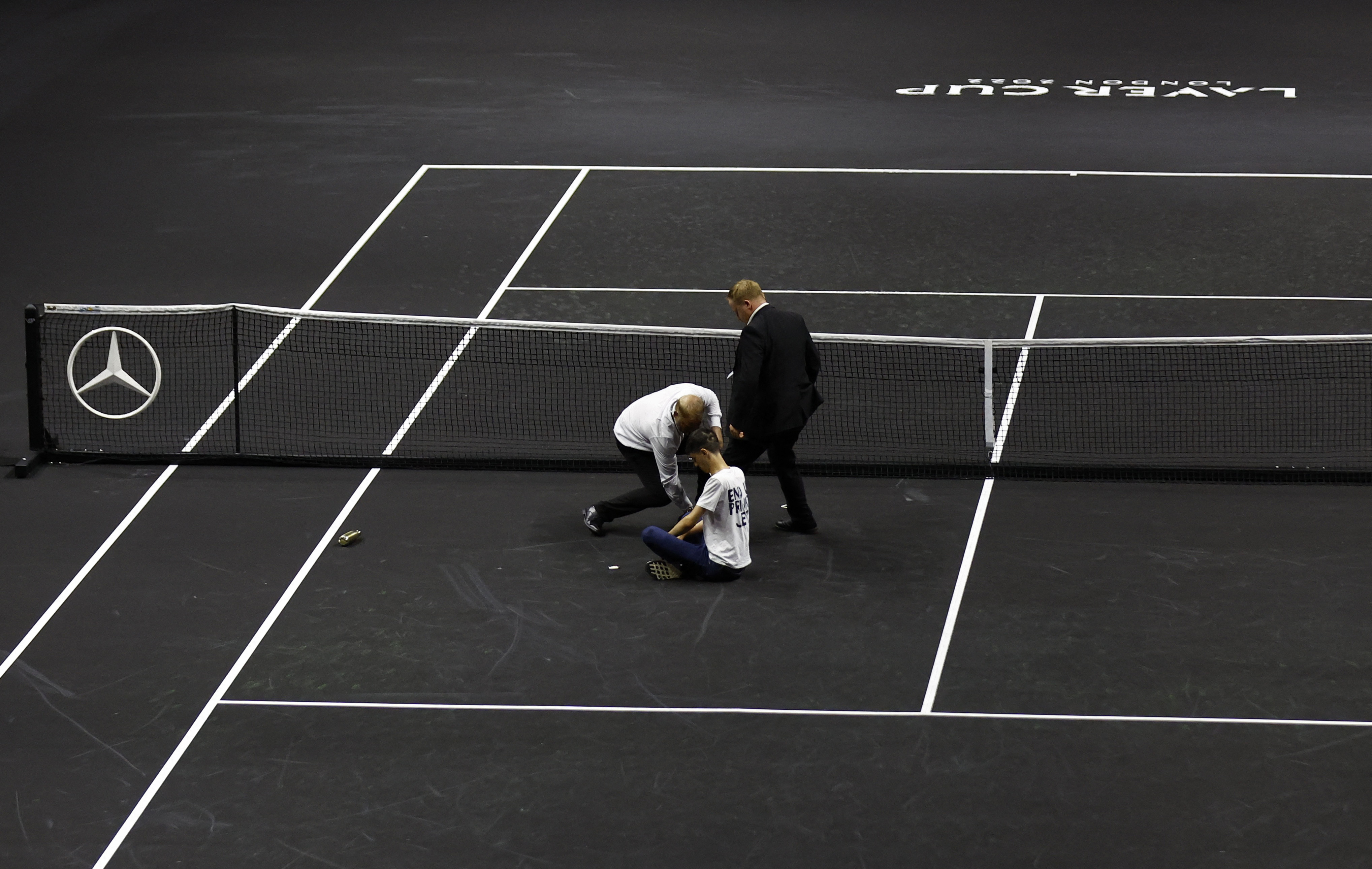 Tennis - Laver Cup - 02 Arena, London, Britain - September 23, 2022   A protester is removed from the court during the match between Team Europe's Stefanos Tsitsipas and Team World's Diego Schwartzman Action Images via Reuters/Andrew Boyers