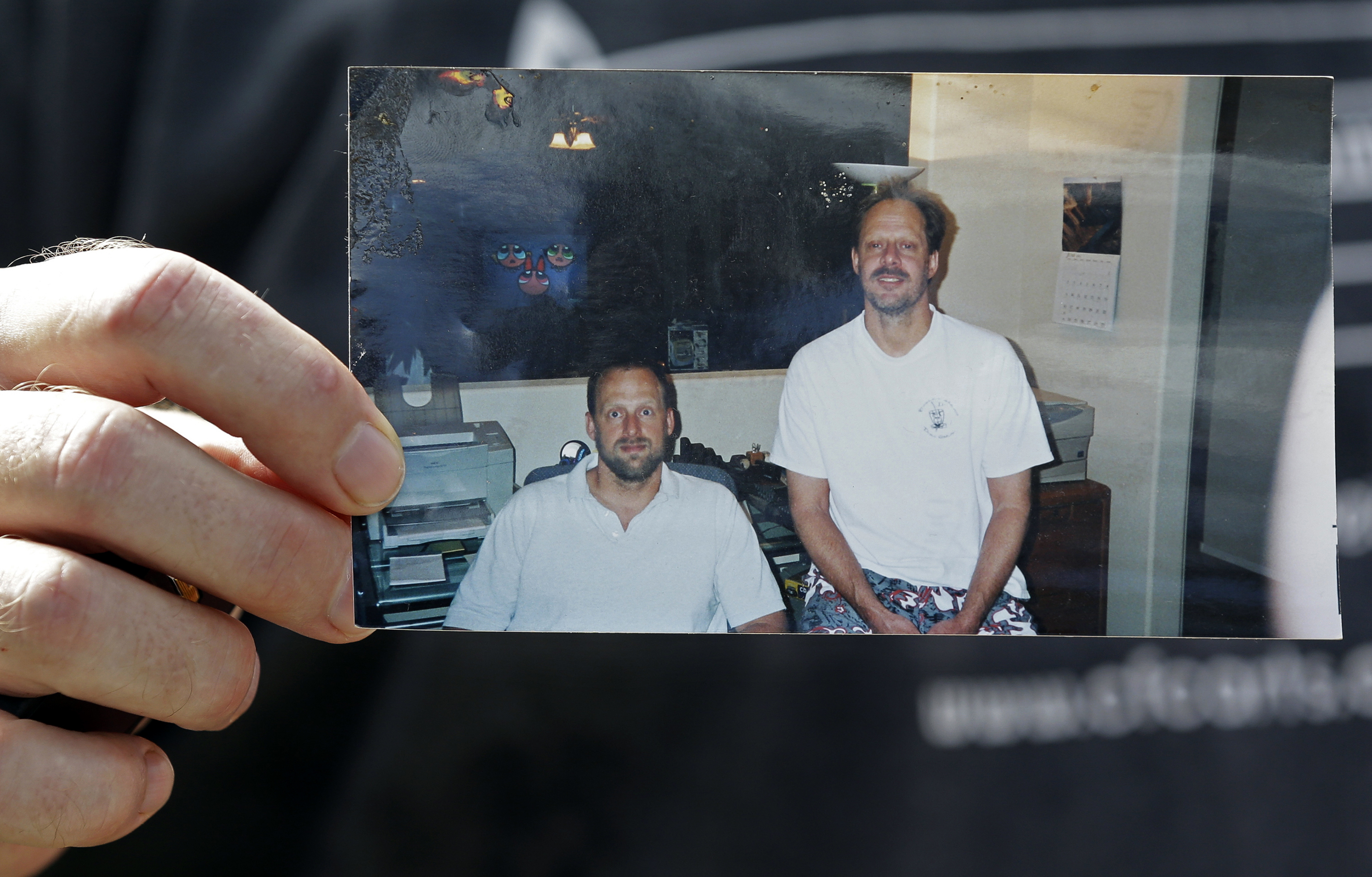 En esta foto del 2 de octubre de 2017, Eric Paddock sostiene una foto de él, a la izquierda, con su hermano, Stephen Paddock, afuera de su casa en Orlando, Florida. Stephen Paddock mató a 60 personas en un tiroteo masivo en 2017 en Las Vegas. (AP Foto/John Raoux, Archivo)