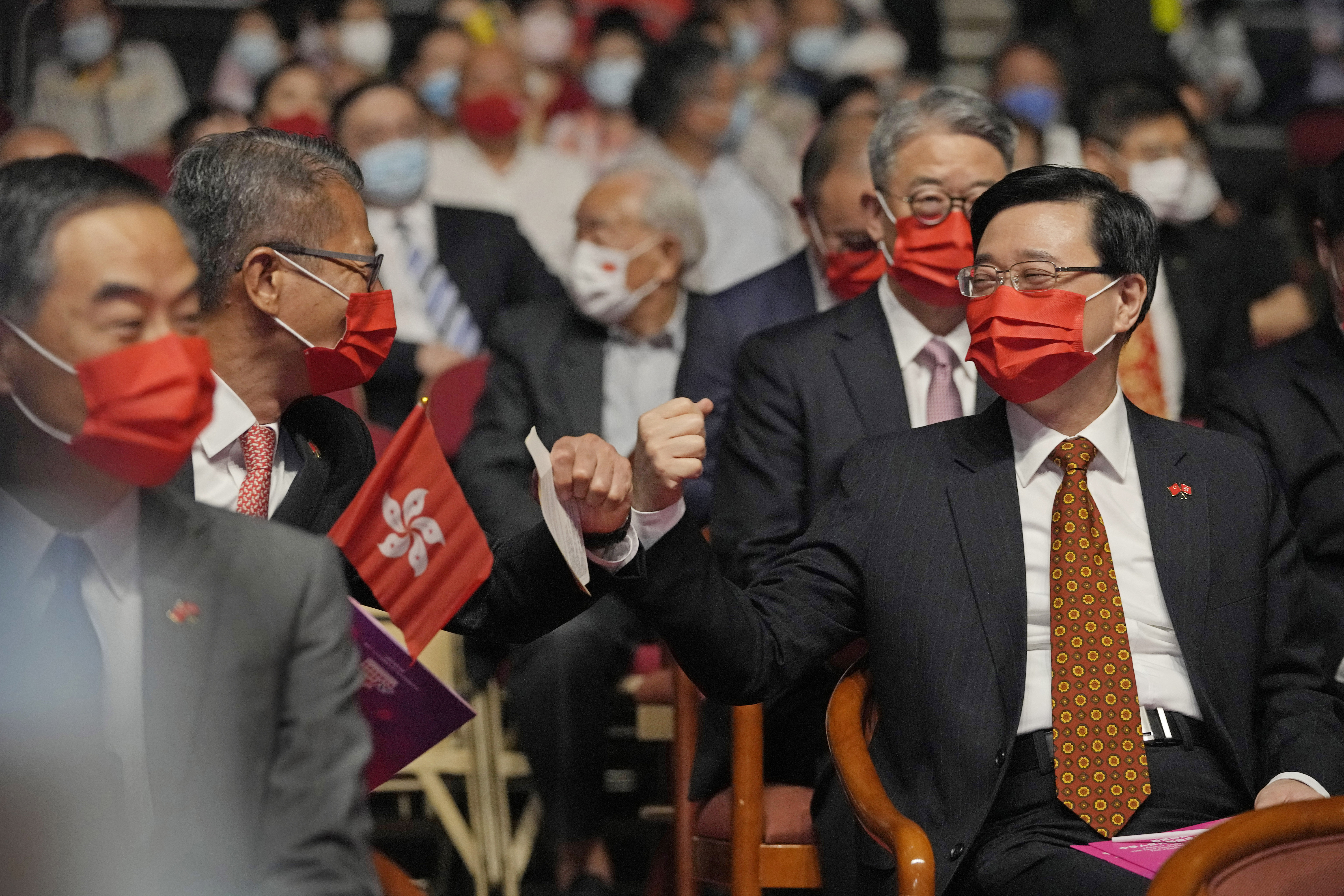 El secretario en jefe de Hong Kong, John Lee, a la derecha, y el ministro de Finanzas, Paul Chan, asisten a un programa de variedades para conmemorar el Día Nacional de China, en Hong Kong, el viernes 1 de octubre de 2021. (Foto AP/Kin Cheung)