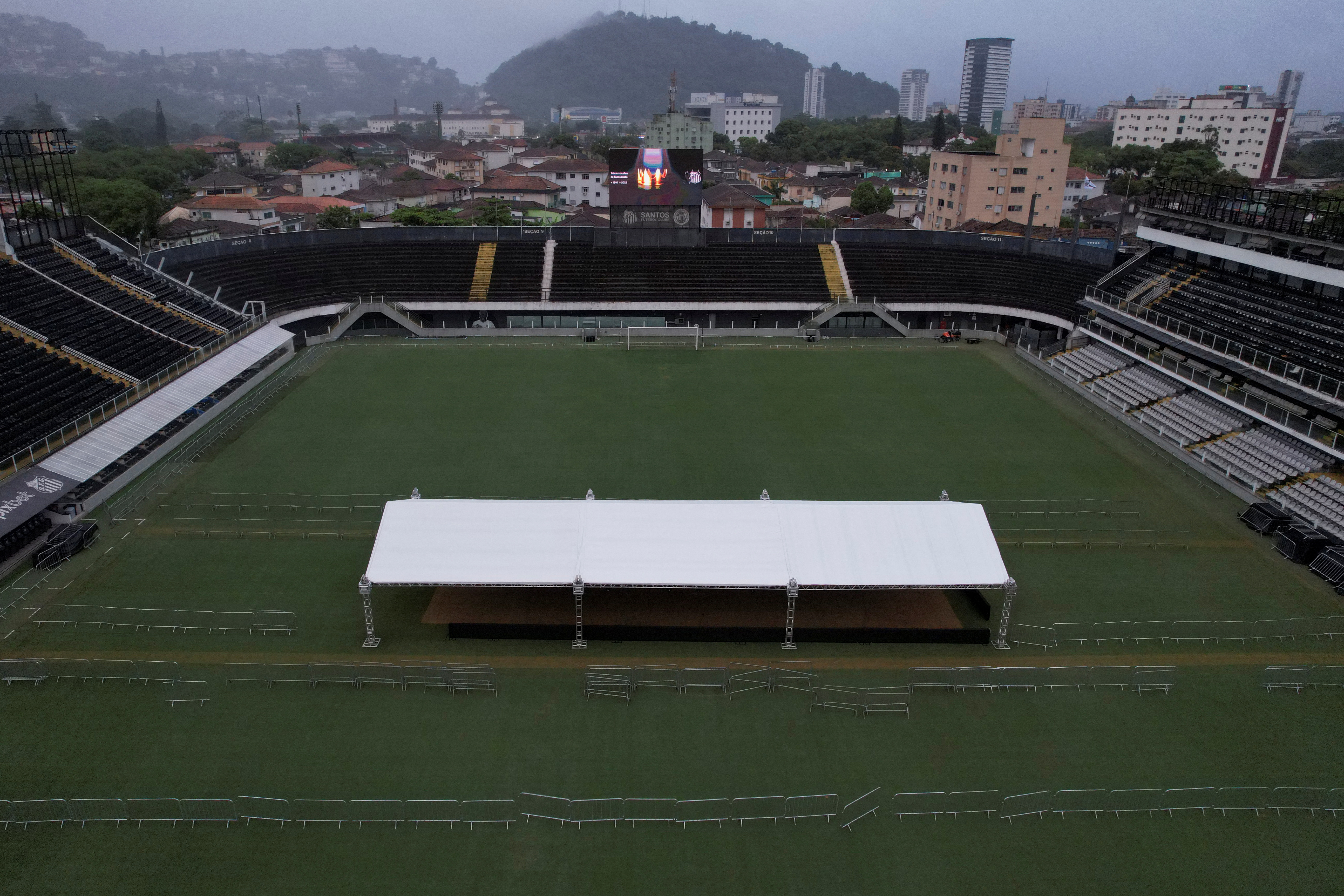An aerial view shows a tent on the pitch of the Vila Belmiro stadium, home of the Santos FC soccer club where Pele played most of his career, as a crown and text that reads ‘Edson Arantes do Nascimento - 1940 - 2022” is displayed on a screen, in Santos, Brazil December 30, 2022. REUTERS/Amanda Perobelli