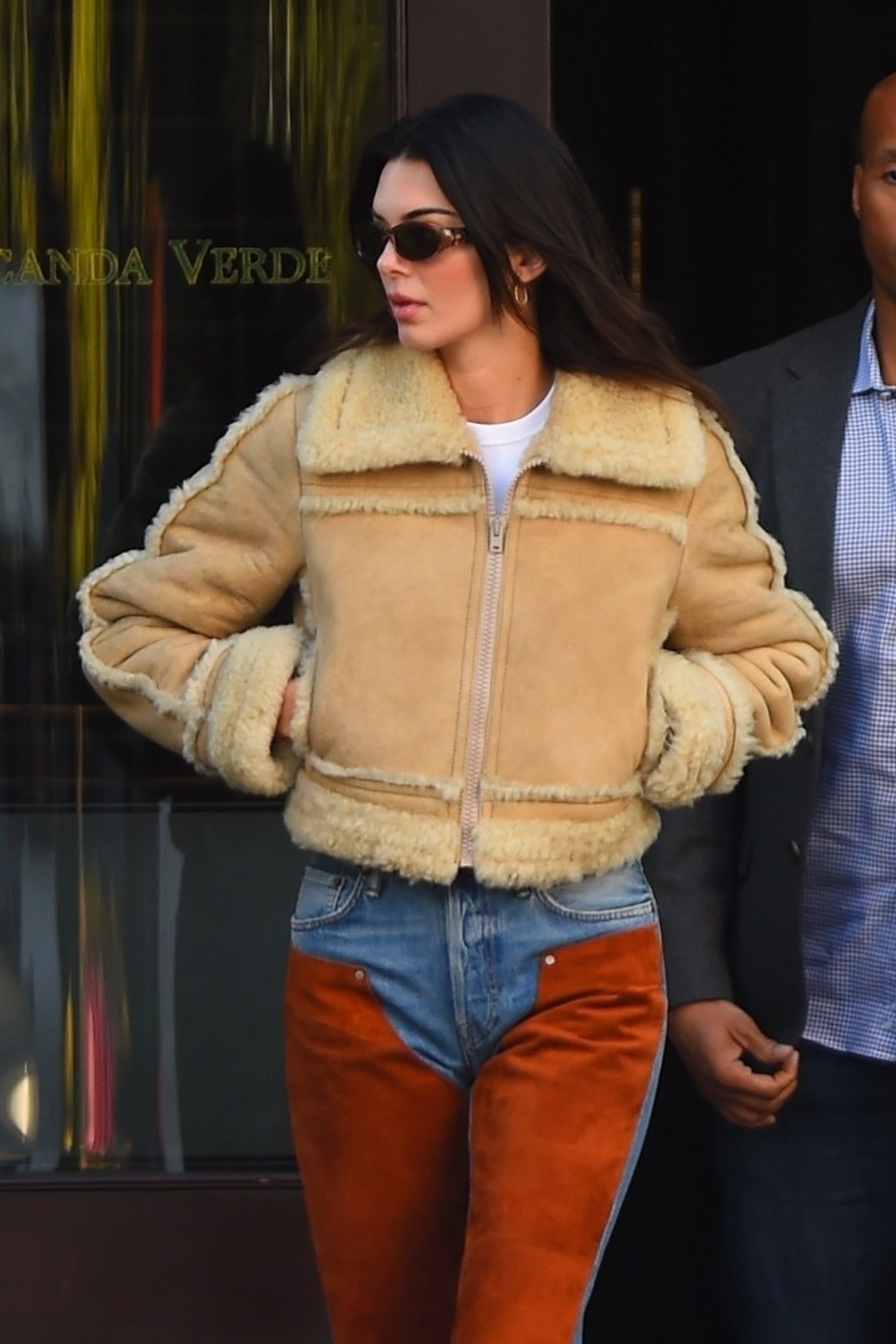La supermodelo Kendall Jenner eligió un atuendo western combinando una chaqueta de aviador beige y un jean con parches de color