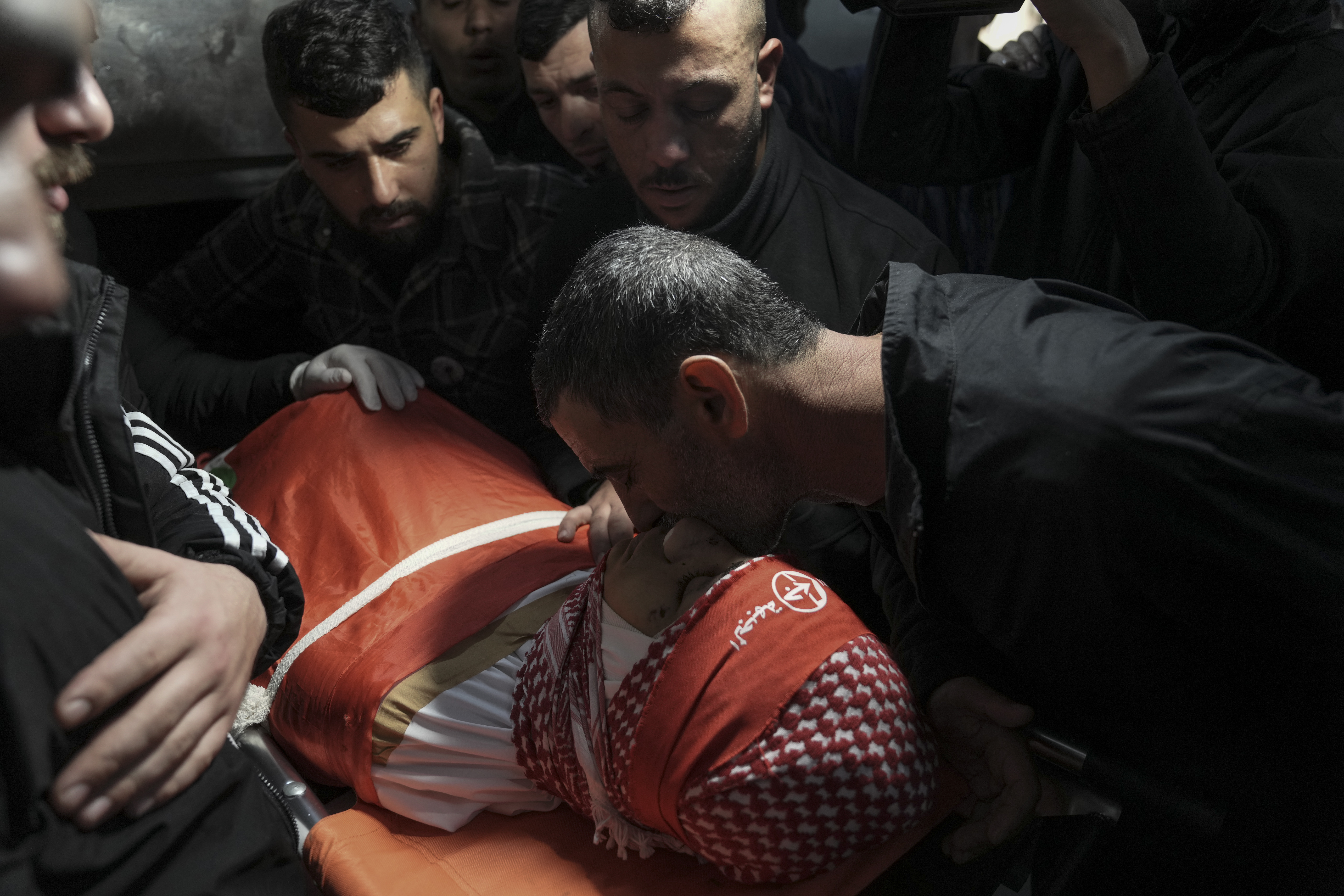 Dolientes asisten al funeral del palestino Omar Khumour, de 14 años, en Belén, Cisjordania, el lunes 16 de enero de 2022. El chico murió de un disparo en la cabeza durante una operación militar israelí en el campamento de refugiados de Dheisha, próxima a la ciudad de Belén. (AP Foto/Mahmoud Illean)