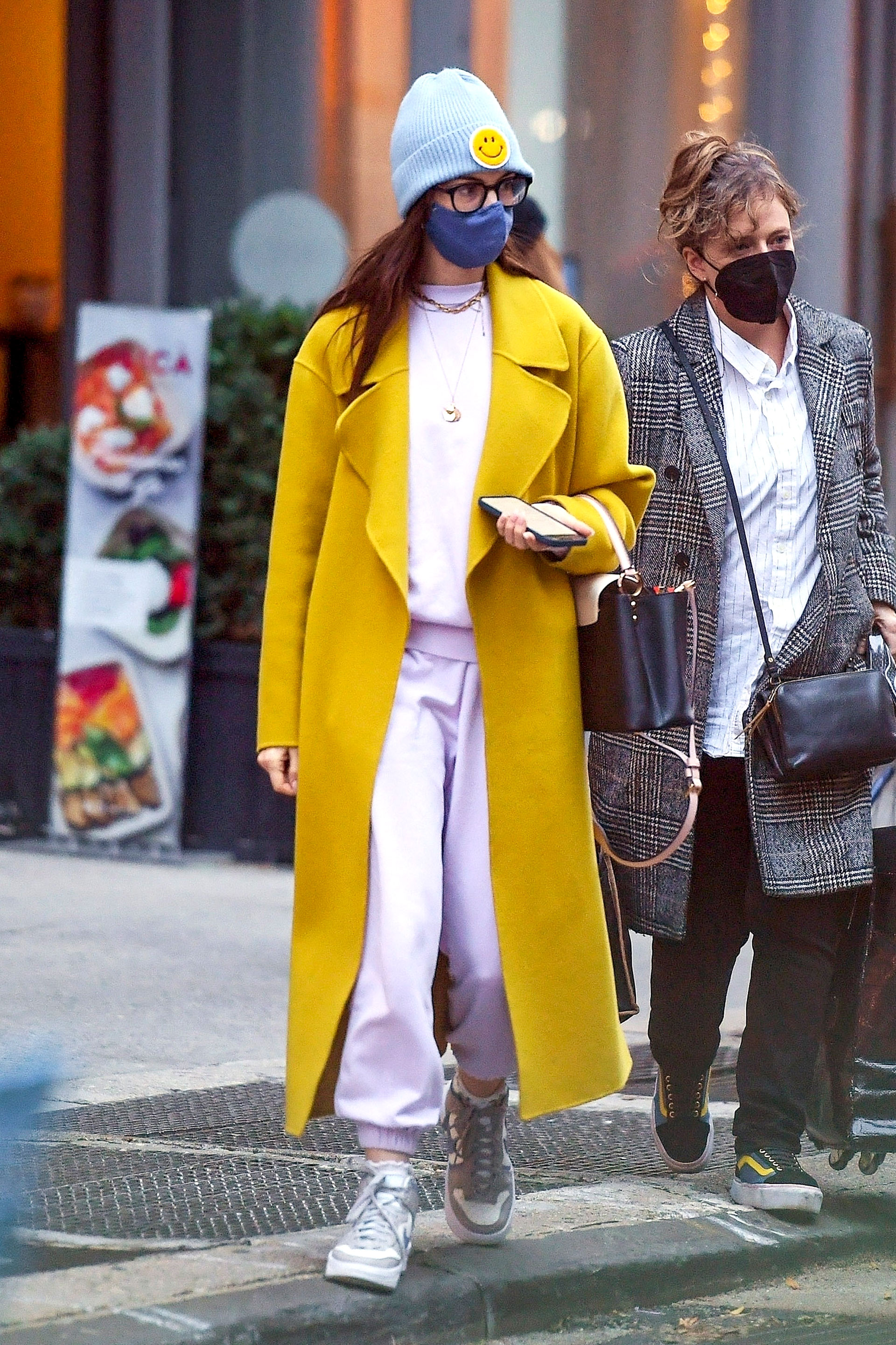 Anne Hathaway salió a pasear por la Gran Manzana con un estilo oversize deportivo y un tapado amarillo que combinó a la perfección con un gorro con una estampa de smile. Cómoda y canchera (Fotos: The Grosby Group)