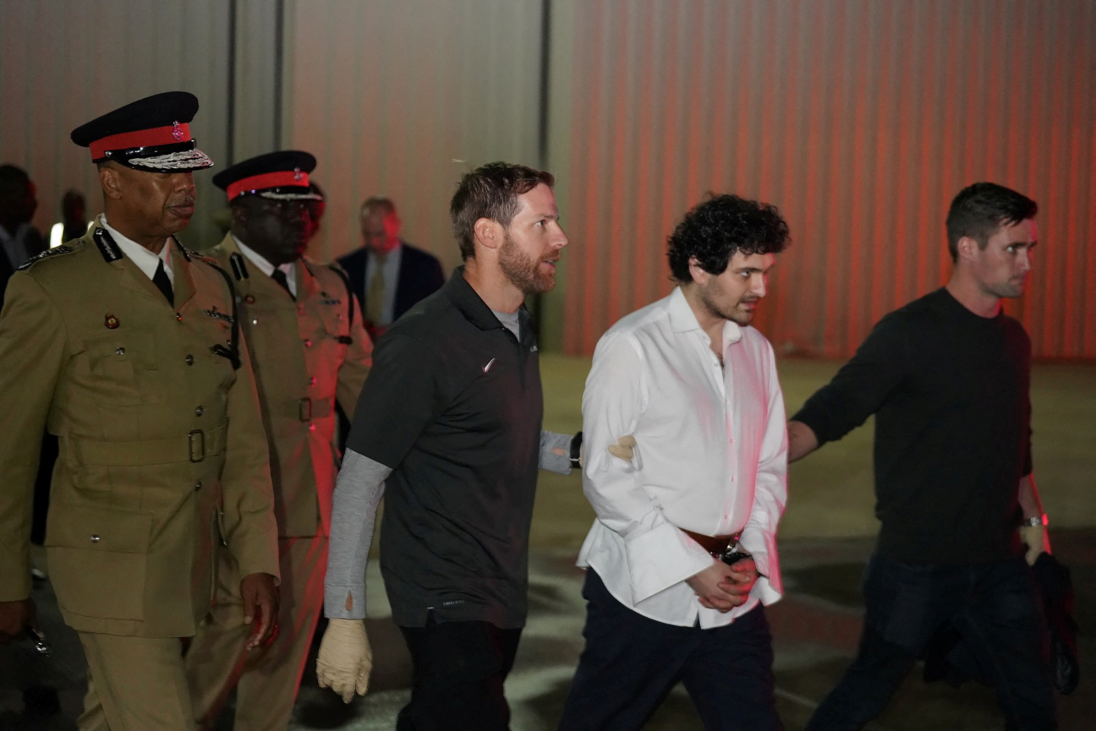 Sam Bankman-Fried, founder and former CEO of crypto currency exchange FTX, is walked in handcuffs to a plane during his extradition to the United States at Lynden Pindling international airport in Nassau, Bahamas December 21, 2022.  Royal Bahamas Police Force/Handout via REUTERS