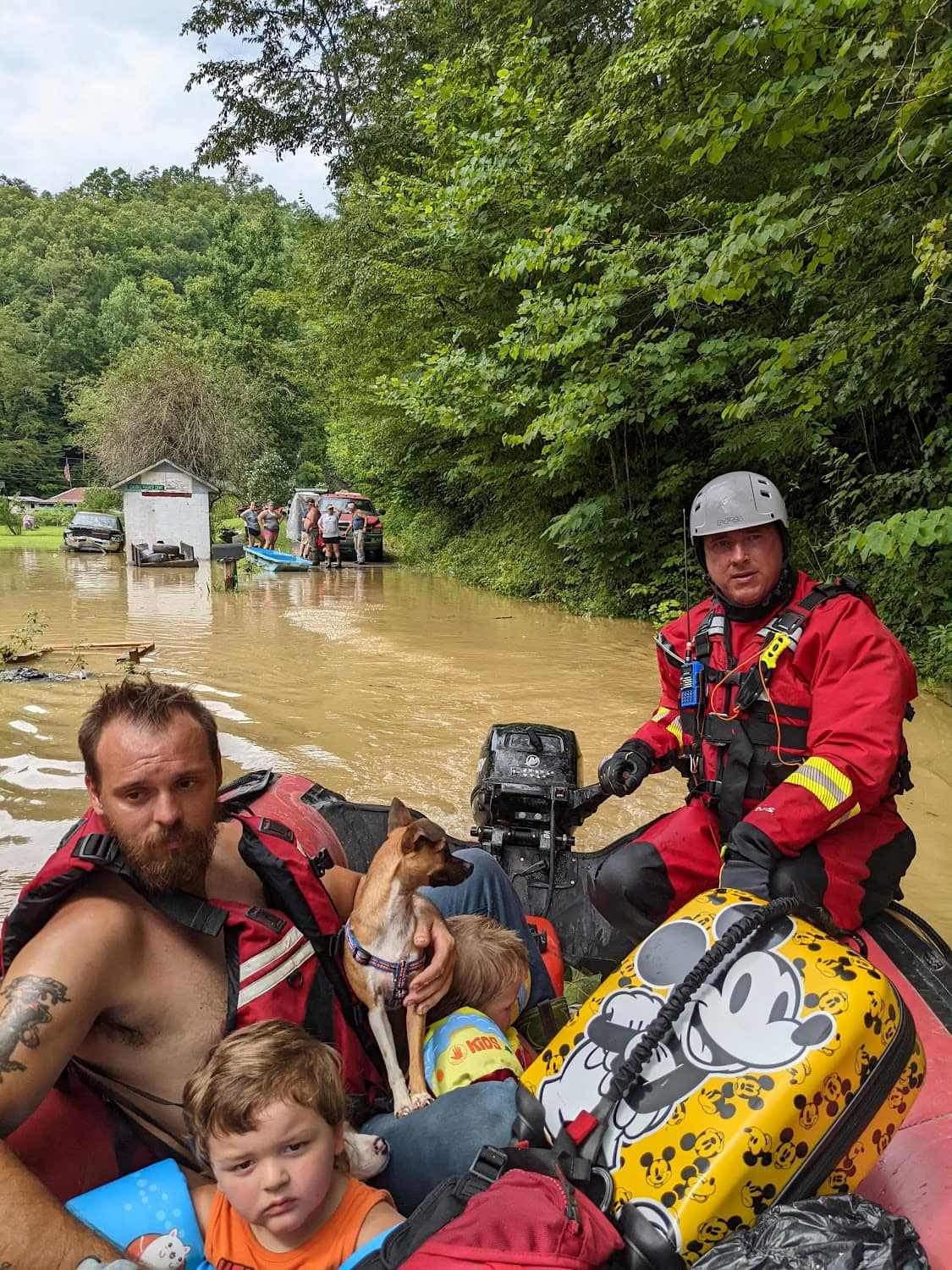Un miembro del equipo de rescate evacúa a los residentes de sus casas en un bote a través de las calles inundadas en el condado de Breathitt, Kentucky, Estados Unidos, el 28 de julio de 2022 (REUTERS)