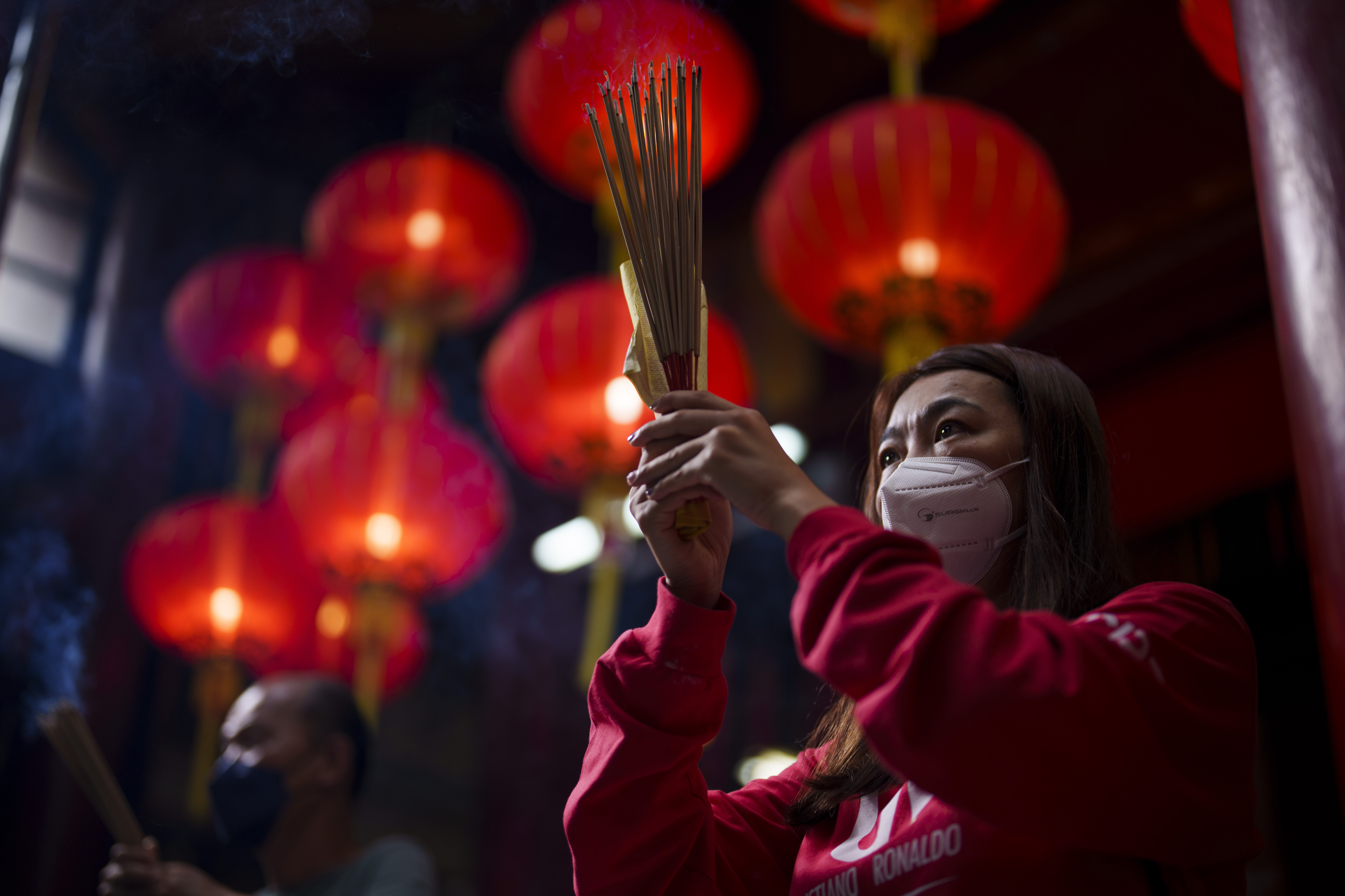 An ethnic Chinese Malay woman prays on the first day of the Lunar New Year at a temple in Kuala Lumpur, Malaysia, Sunday, Jan. 22, 2023. (AP Photo/Vincent Thian)