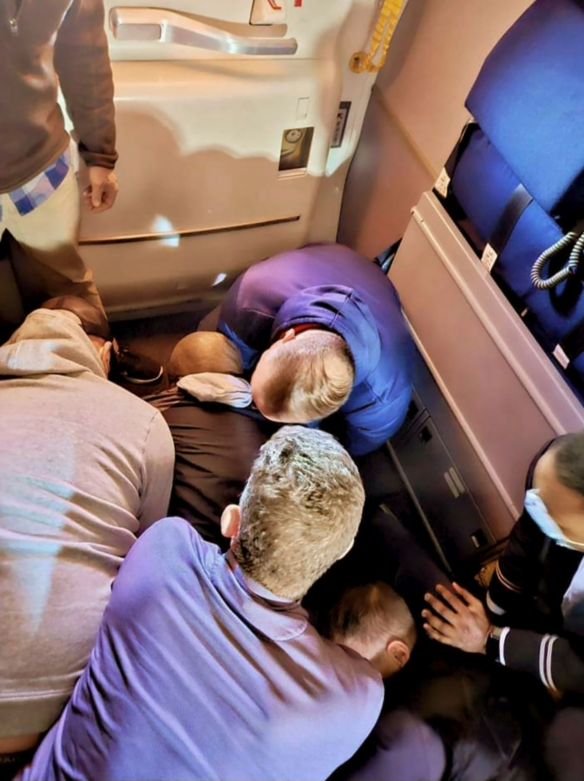 Esta imagen muestra a pasajeros y miembros de la tripulación sujetando a Torres en un vuelo de Los Ángeles a Boston el domingo 5 de marzo de 2023 (AP)