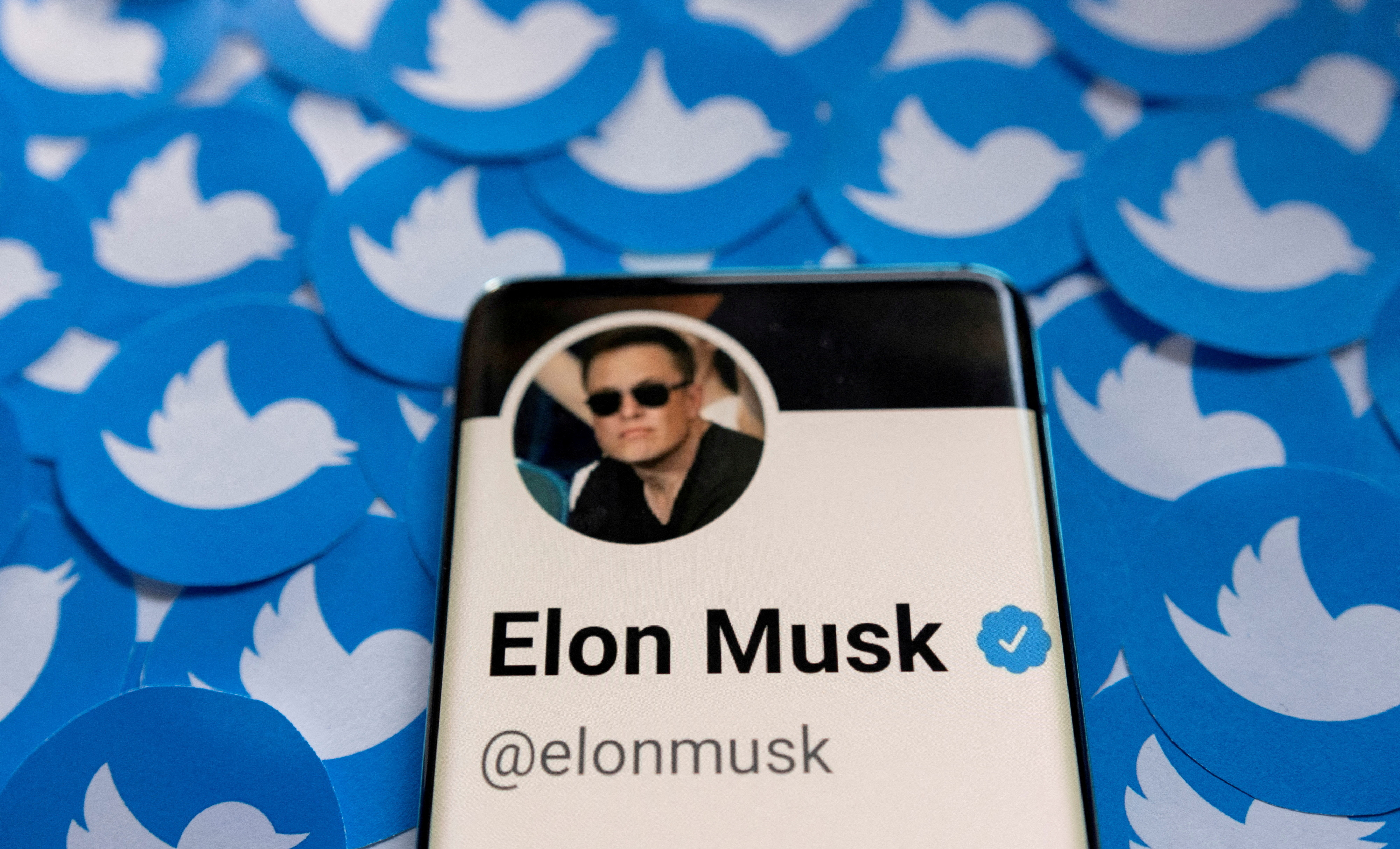 FILE PHOTO: Il profilo Twitter di Elon Musk appare su uno smartphone posizionato sui loghi Twitter stampati in questa illustrazione fotografica il 28 aprile 2022. REUTERS/Dado Ruvic/Illustration/File Photo