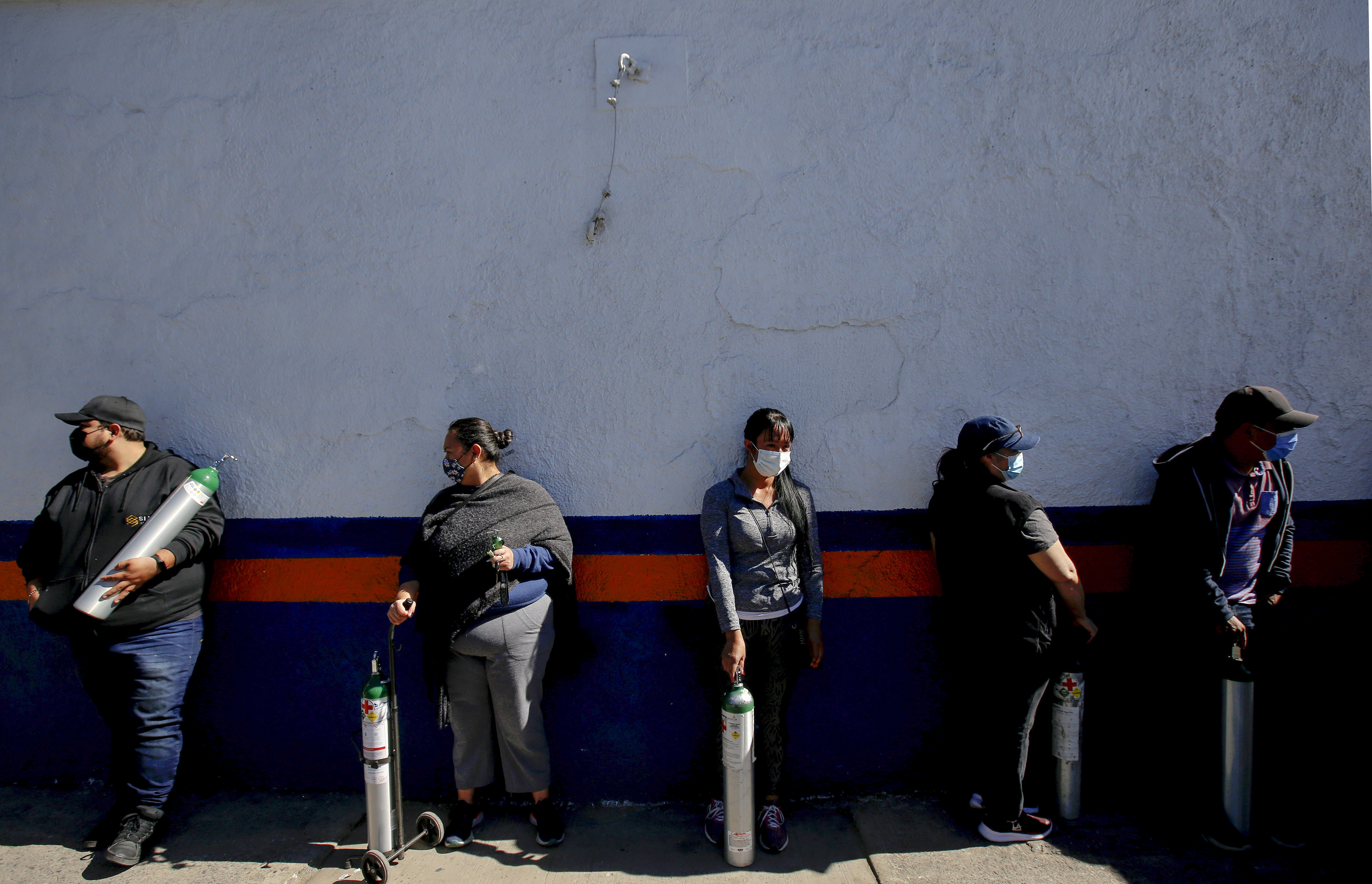 Personas hacen cola para recargar los tanques de oxígeno de sus familiares infectados con COVID-19, debido a la escasez de gas medicinal luego de un aumento en los casos de coronavirus, en Guadalajara, Estado de Jalisco, México el 17 de enero de 2021.