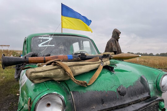 Un soldado ucraniano junto a un coche marcado con el emblema ruso "Z" en Velyki Prokhody tras la liberación del pueblo. En el capó del coche hay un lanzagranadas propulsado por cohete. (Global Images Ucrania/Getty Images)