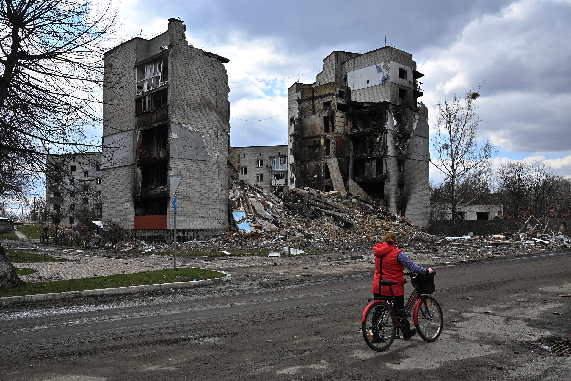 Una mujer pasa con su bicicleta por un edificio destruido en Borodianka (fotos: Sergei Supinsky/AFP)