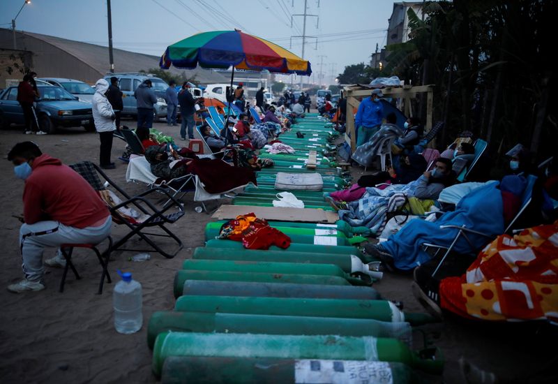 Gente espera junto a tanques de oxígeno vacíos para llenarlos para los pacientes que sufren de COVID-19 en Lima, Perú, el 25 de febrero de 2021 (REUTERS/Sebastián Castañeda)