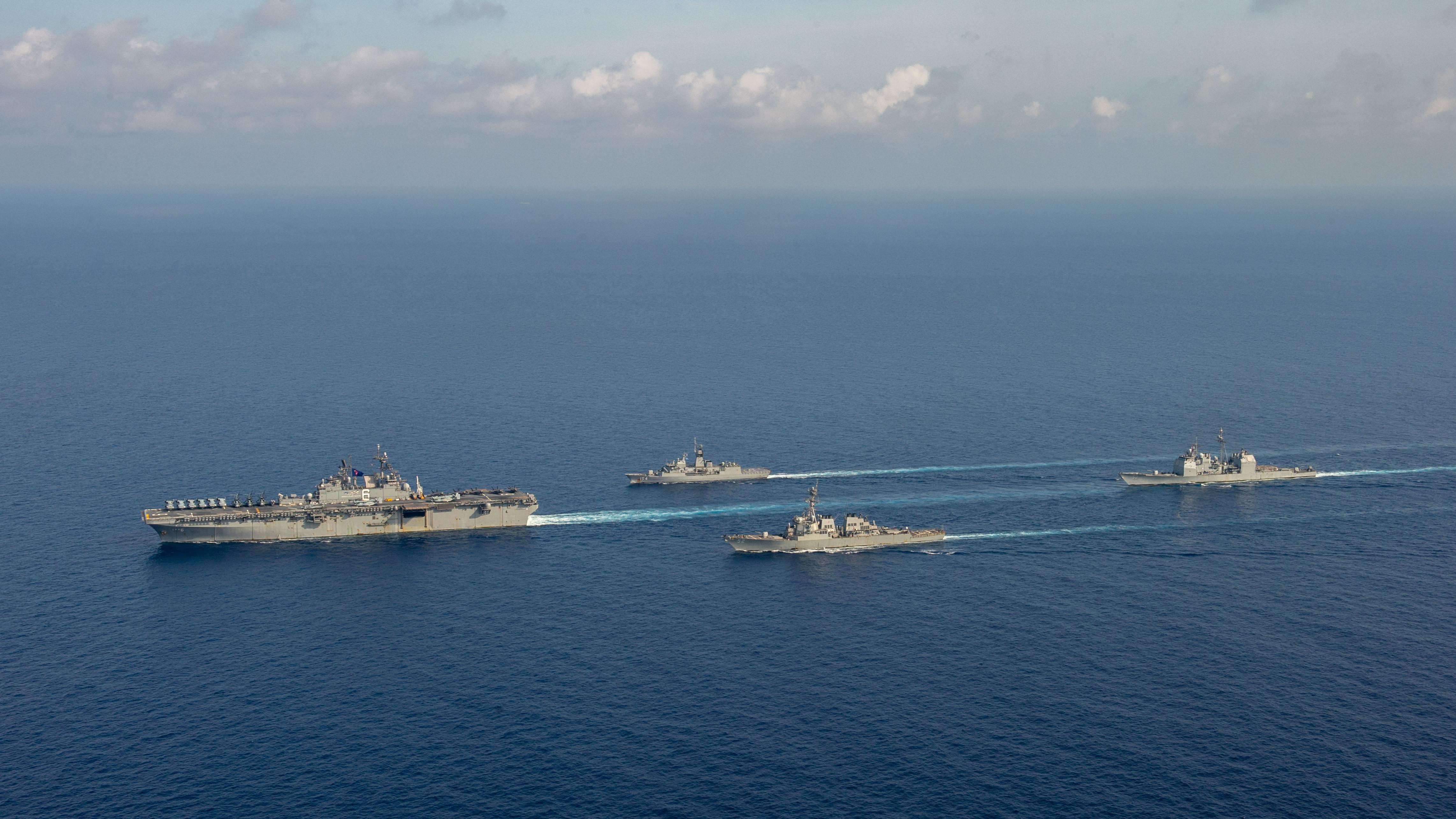 Los buques estadounidenses y un helicóptero australiano durante unos ejercicios en el Mar de China meridional (Departamento de Defensa australiano/Handout via REUTERS)