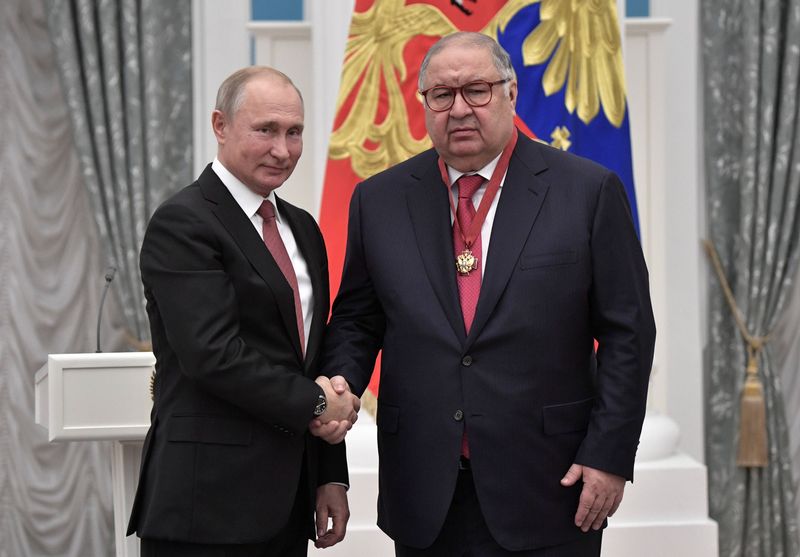 El presidente ruso Vladimir Putin estrecha la mano del Alisher Usmanov, uno de los oligarcas apuntados por las sanciones internacionales. (foto Reuters)