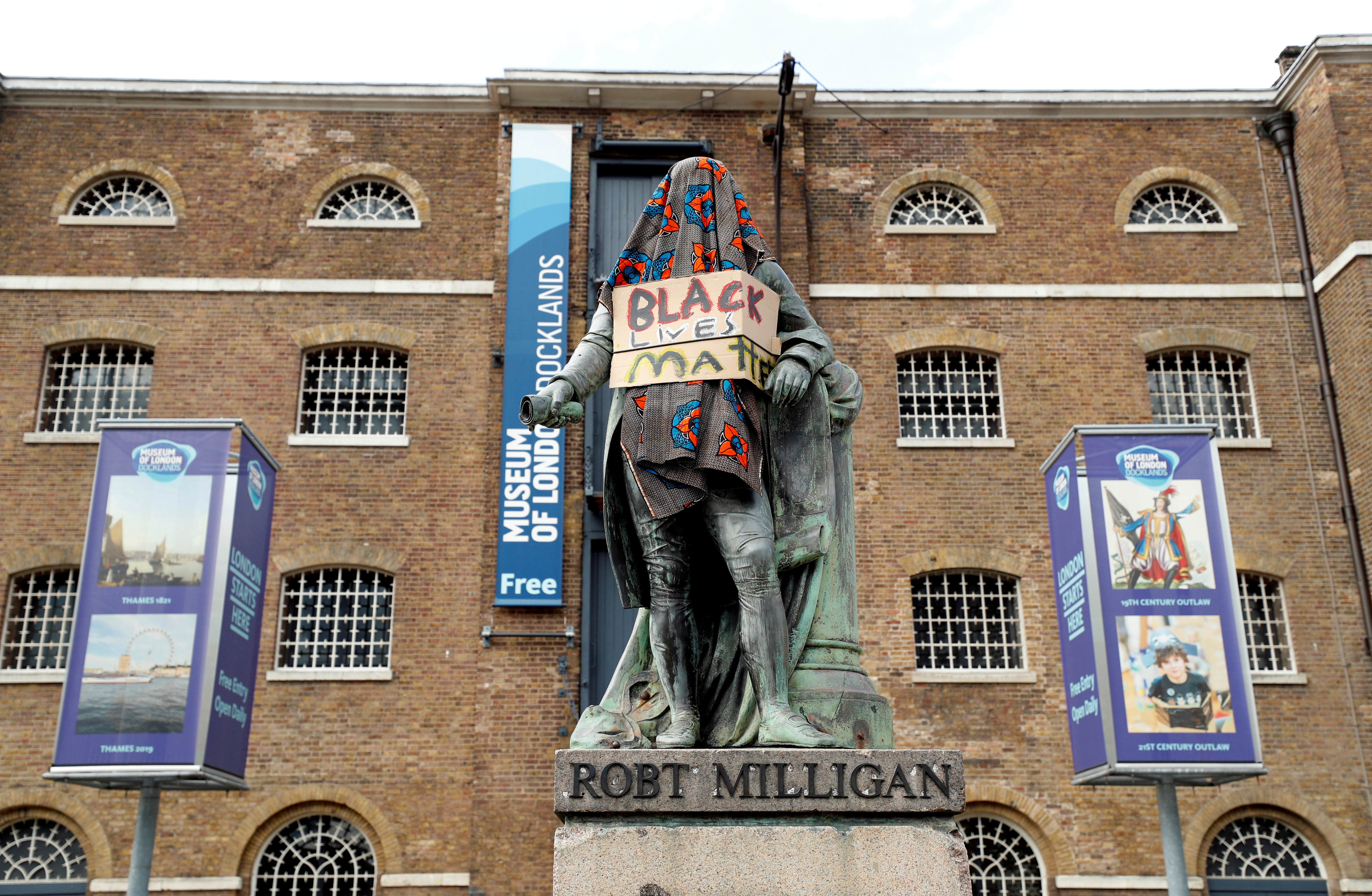 La estatua de Robert Milligan tapada con una manta y con un cartel de Black Lives Matter afuera del Museo de los Docklands de Londres. Gran Bretaña, 9 de junio de 2020 (Foto: John Sibley / REUTERS)