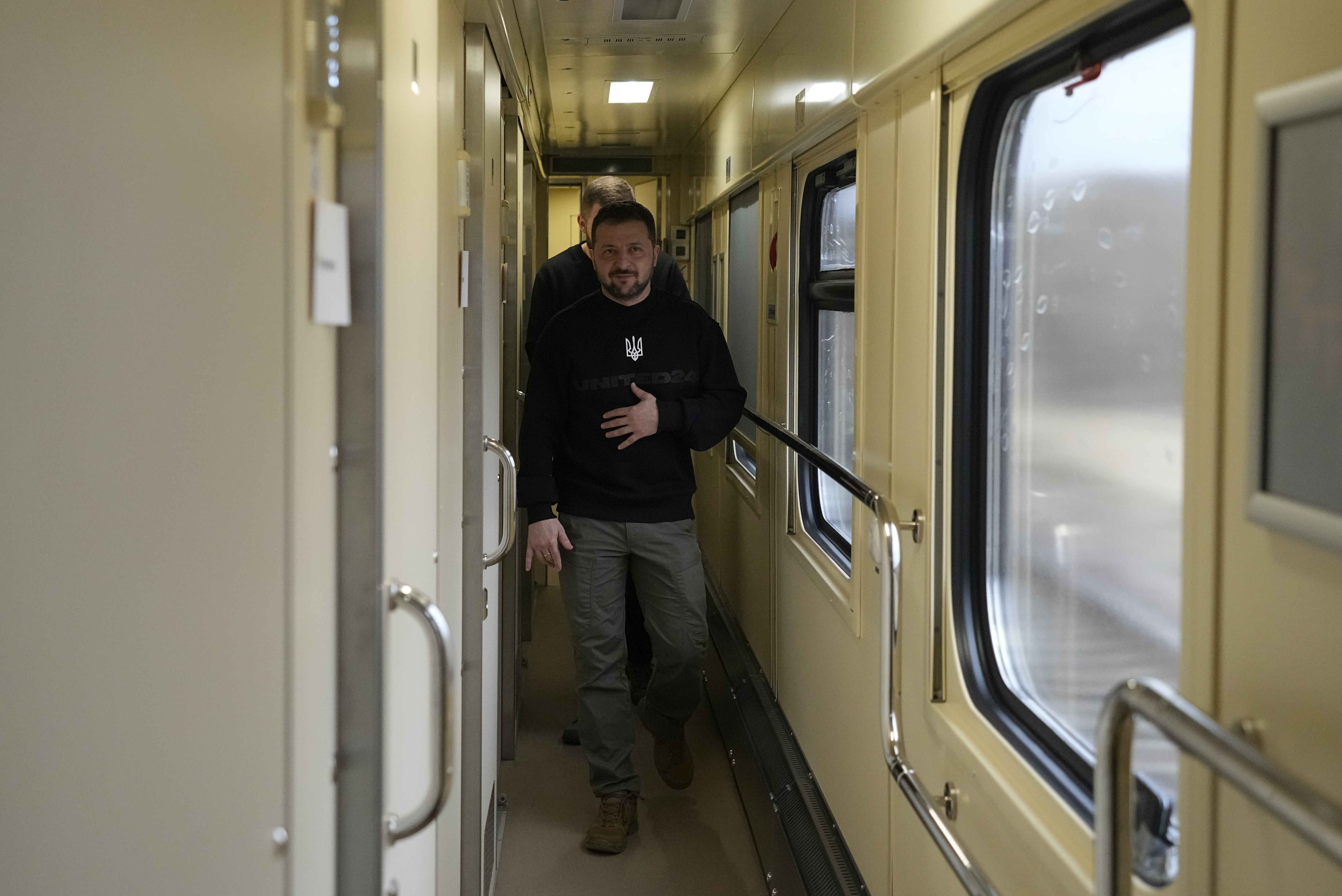 Ukraine's President Volodymyr Zelenskyy walks down a corridor upon his arrival for an interview with The Associated Press on a train en route from the Sumy region to Kiev, Ukraine, Tuesday, March 28, 2023. (AP Photo/Efrem Lukatsky )