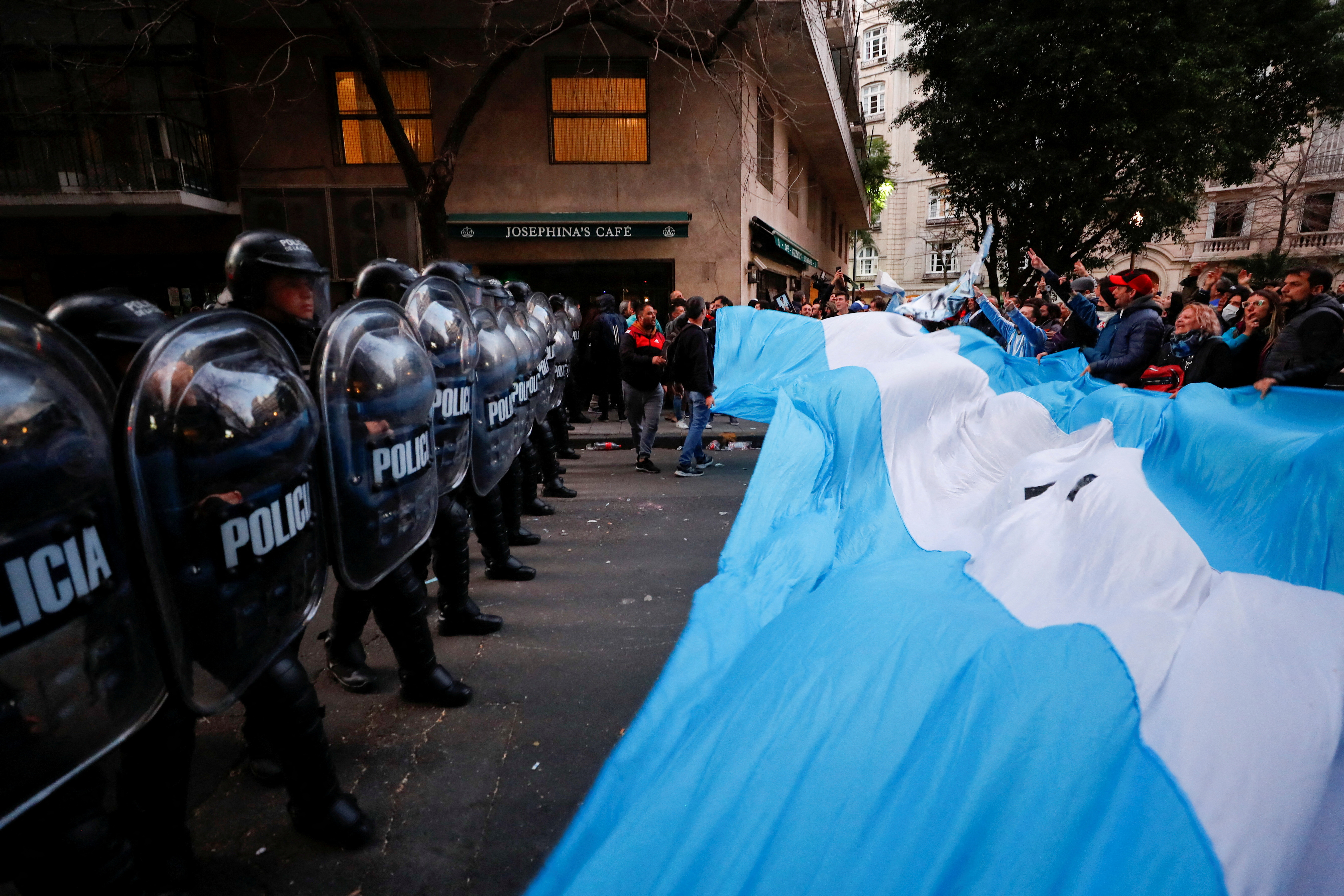 Supporters gather outside the house of Argentina's Vice President Cristina Fernandez de Kirchner as police officers hold their shields, days after Fernandez was accused in a corruption case, in Buenos Aires, Argentina, August 27, 2022. REUTERS/Agustin Marcarian     TPX IMAGES OF THE DAY