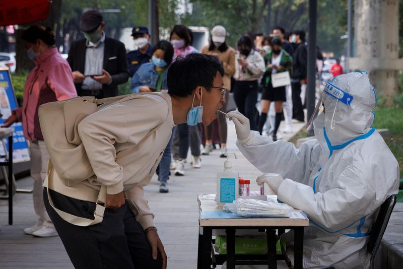 Un hombre se somete a una prueba para detectar el coronavirus instalada para rastrear posibles brotes de la enfermedad por coronavirus (COVID-19) en Beijing, China. 7 de octubre de 2022. REUTERS/Thomas Peter/Archivo
