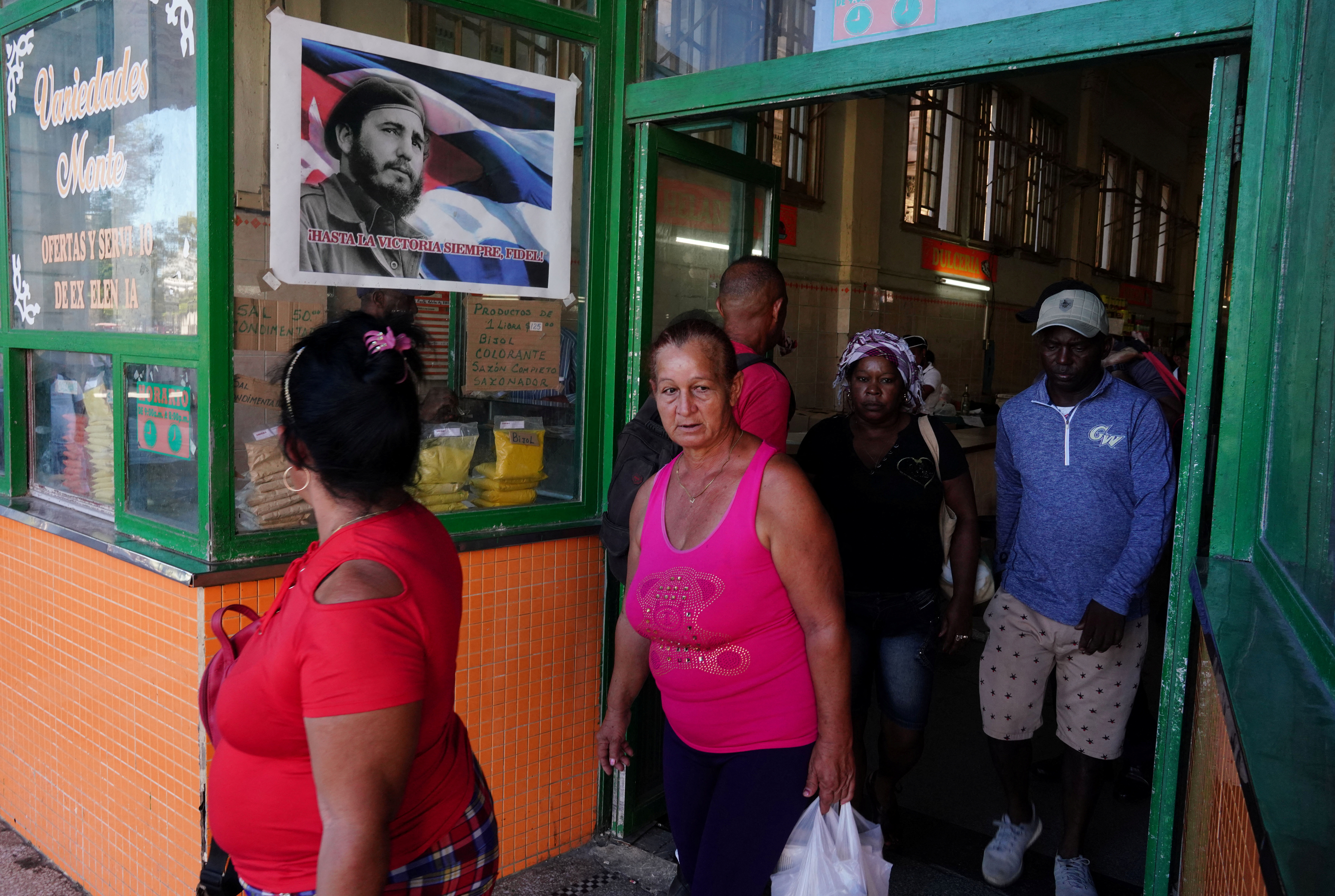 La gente sale de una tienda que muestra una imagen del fallecido Fidel Castro, en el centro de La Habana, Cuba (Archivo/Reuters)