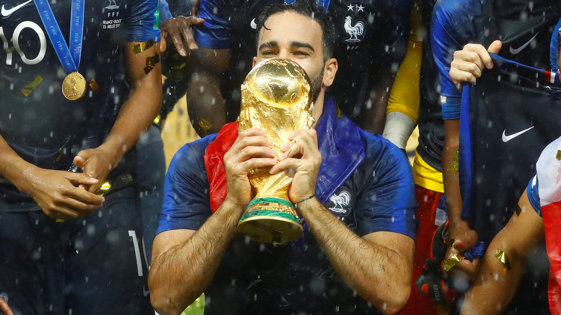 Adil Rami holds the World Cup in his hands amid France's 2018 celebration
