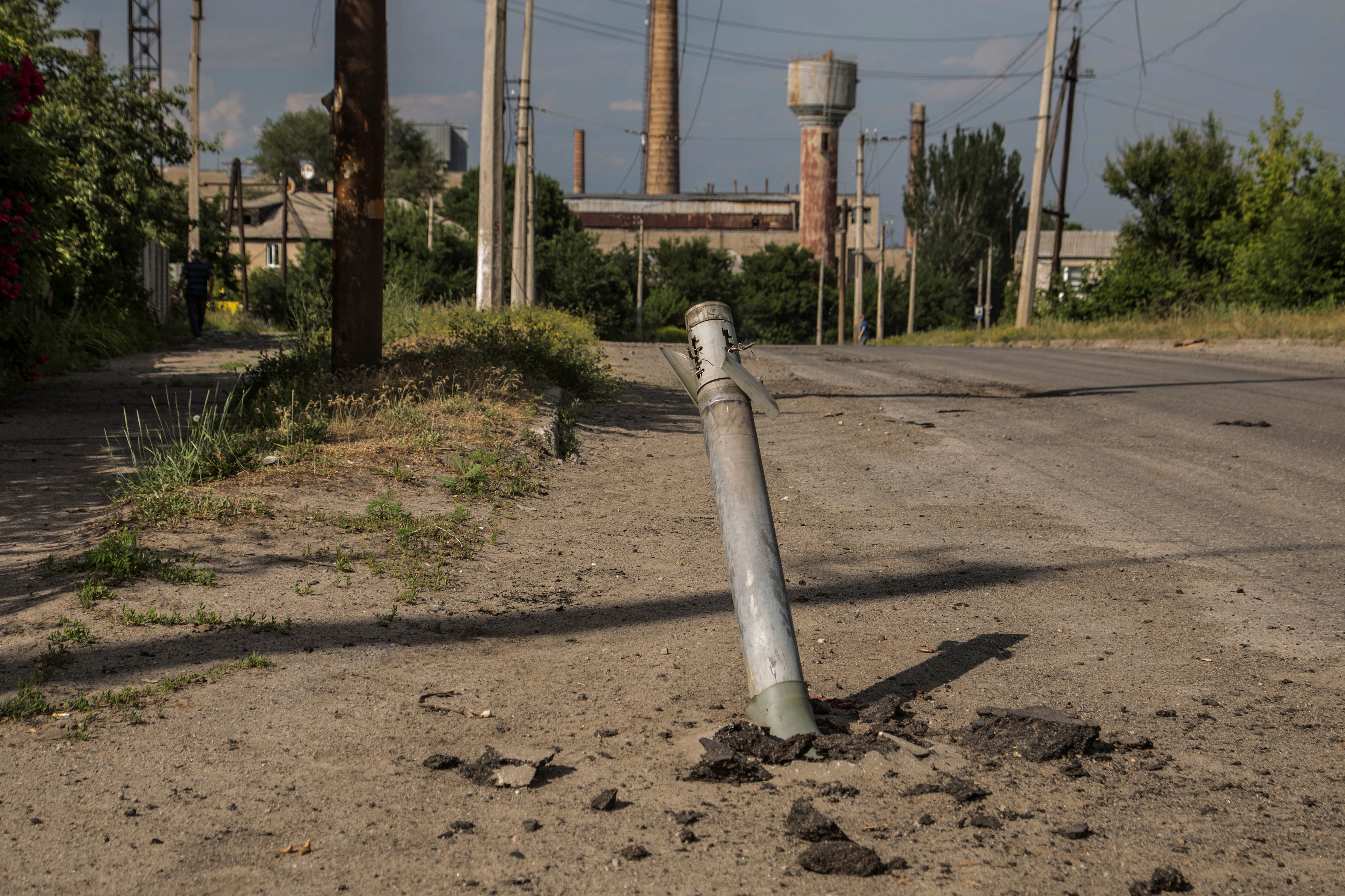 Un proyectil sin explotar de un sistema de lanzamiento de cohetes múltiples se ve atascado entre una calle en Lisychansk, región de Luhansk, Ucrania 17 de junio de 2022.  (REUTERS/Oleksandr Ratushniak)